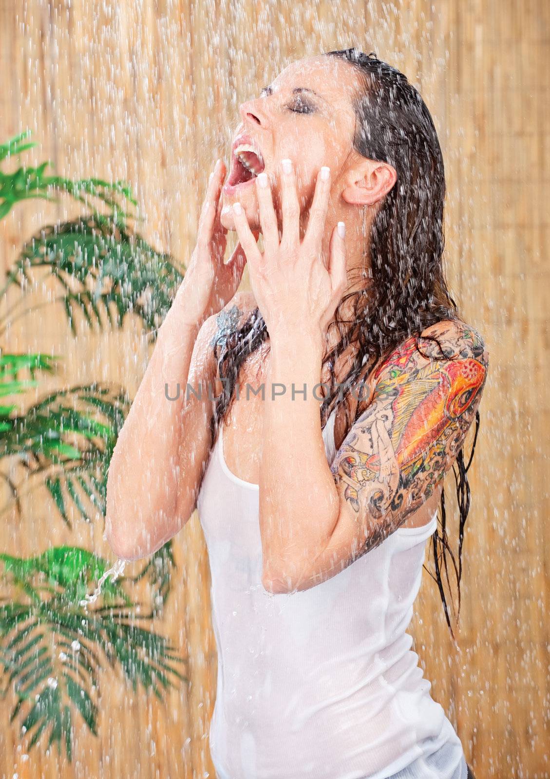 young woman in white shirt with tattoo on her hand under shower