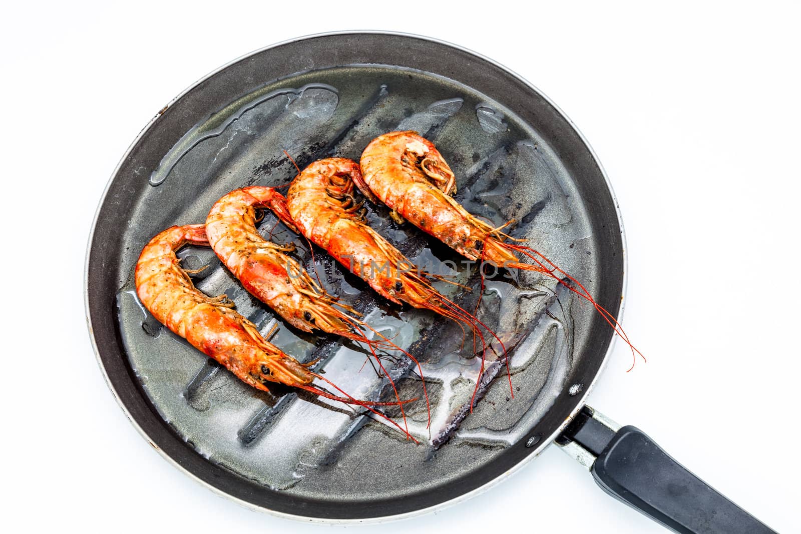 Grilled shrimp on a griddle on a white background