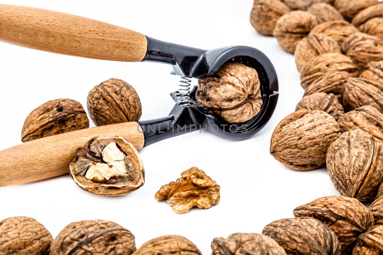 A composition of walnuts, cracked walnuts and a nutcraker