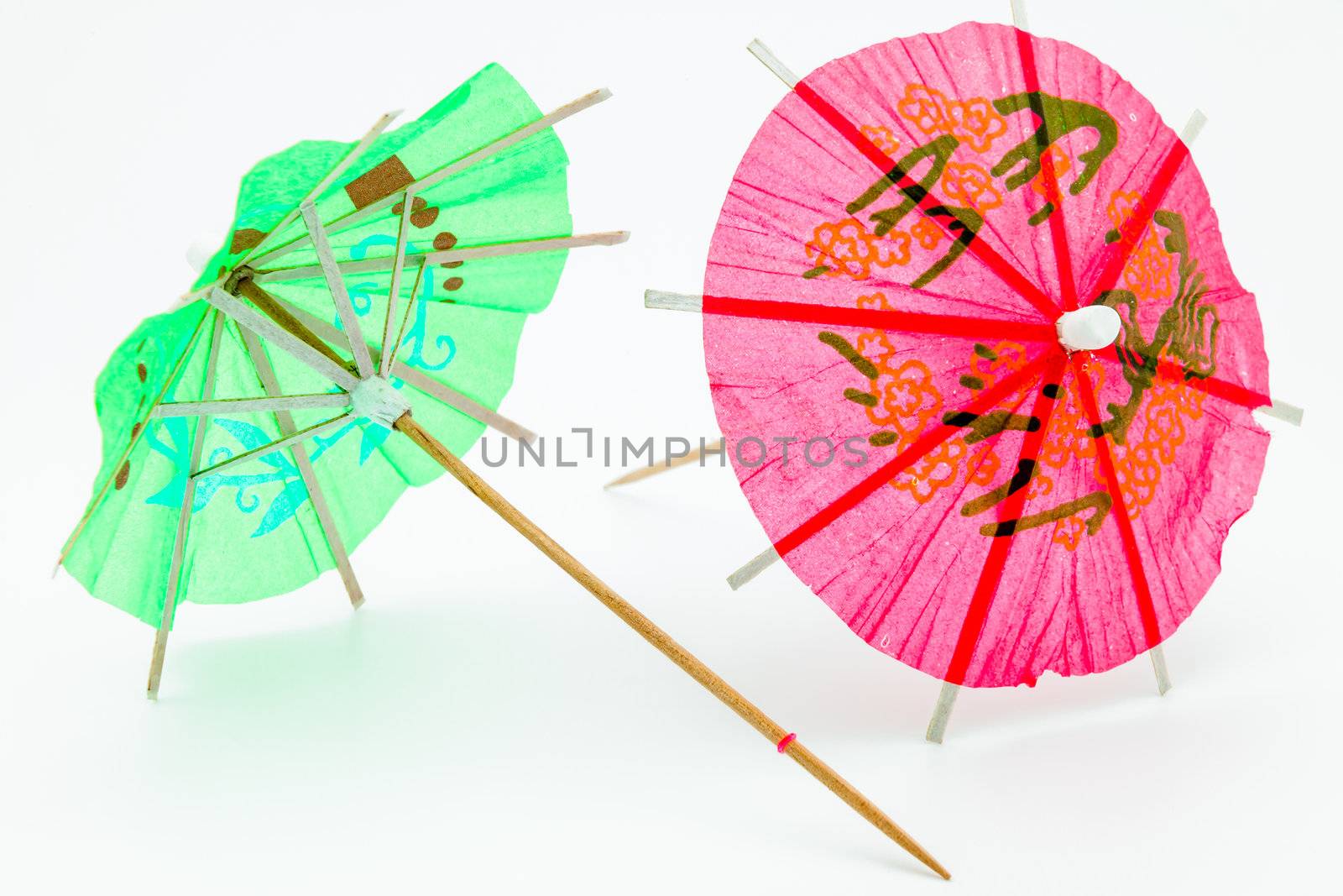 Two cocktail umbrellas on a white background