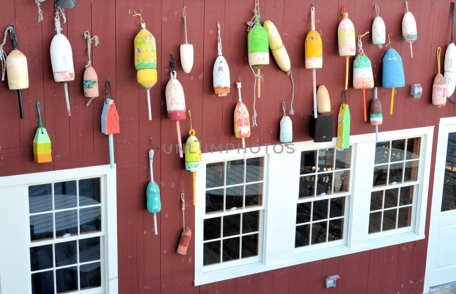 Old lobster bouys along a wall at a seaside eatery