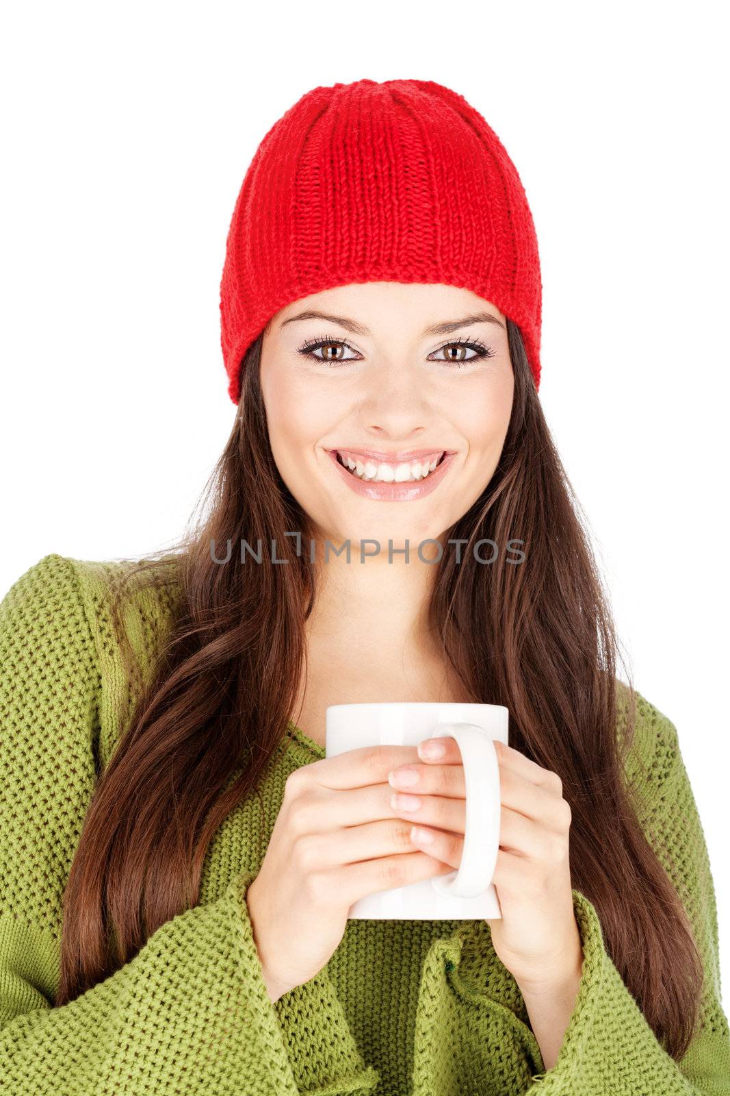 young happy brunette woman in wool sweater and cap holding a teapot, isolated on white