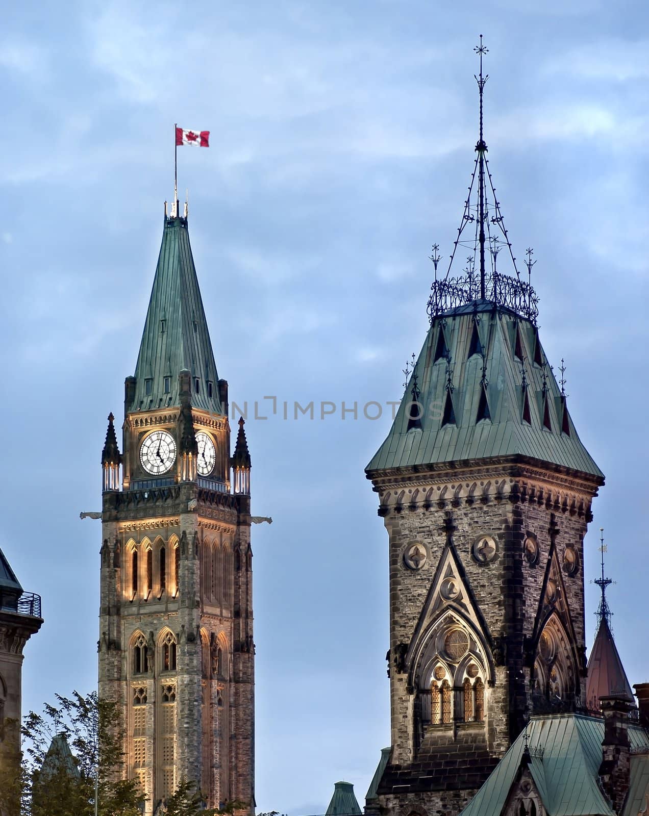 The Canadian Parliament Centre and East Blocks with the Maple Leaf flag in Ottawa, Ontario, Canada.