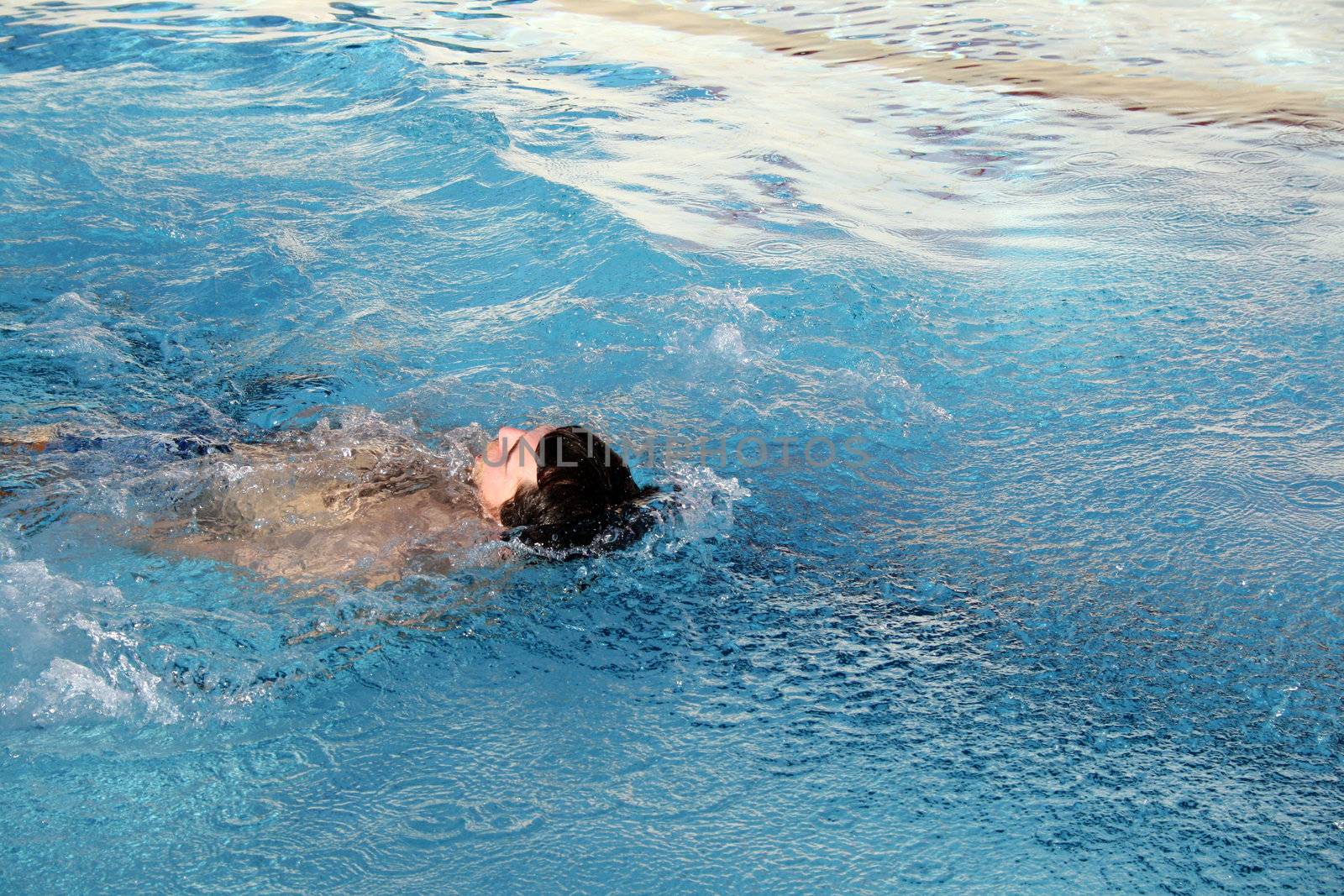 man swims in swimming pool