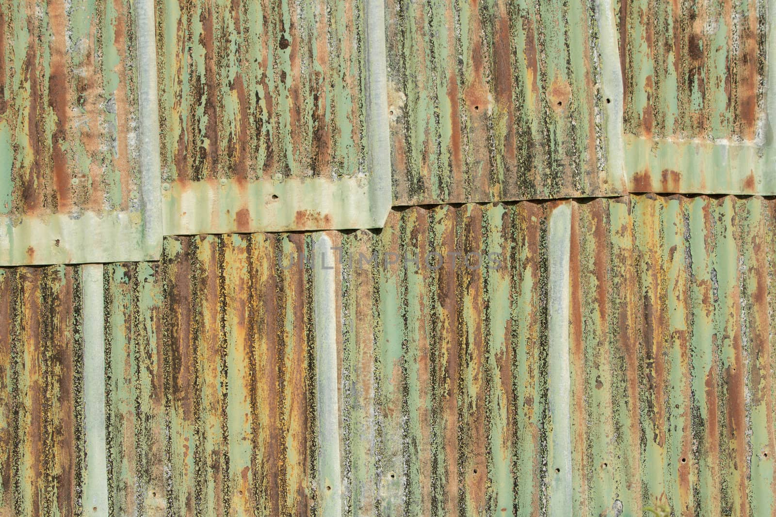 A background of metal sheets overlapping with various shades of color paint and rust.