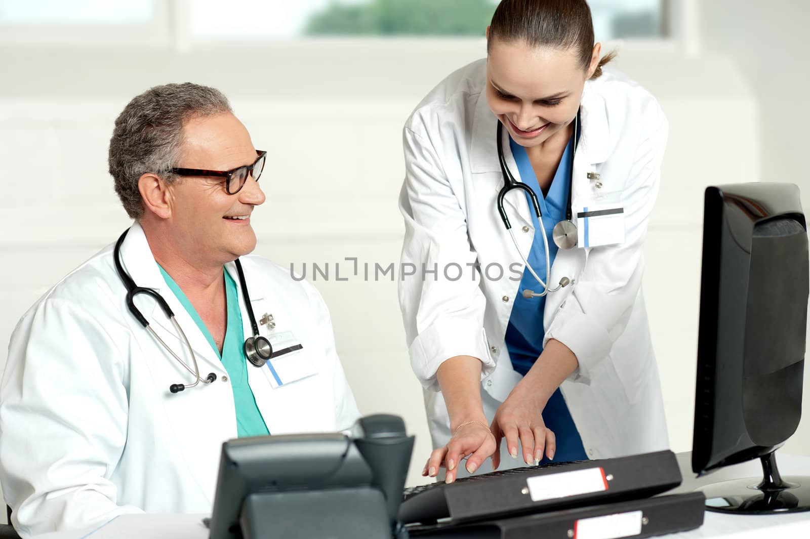 Smiling medical team working on computer in a hospital