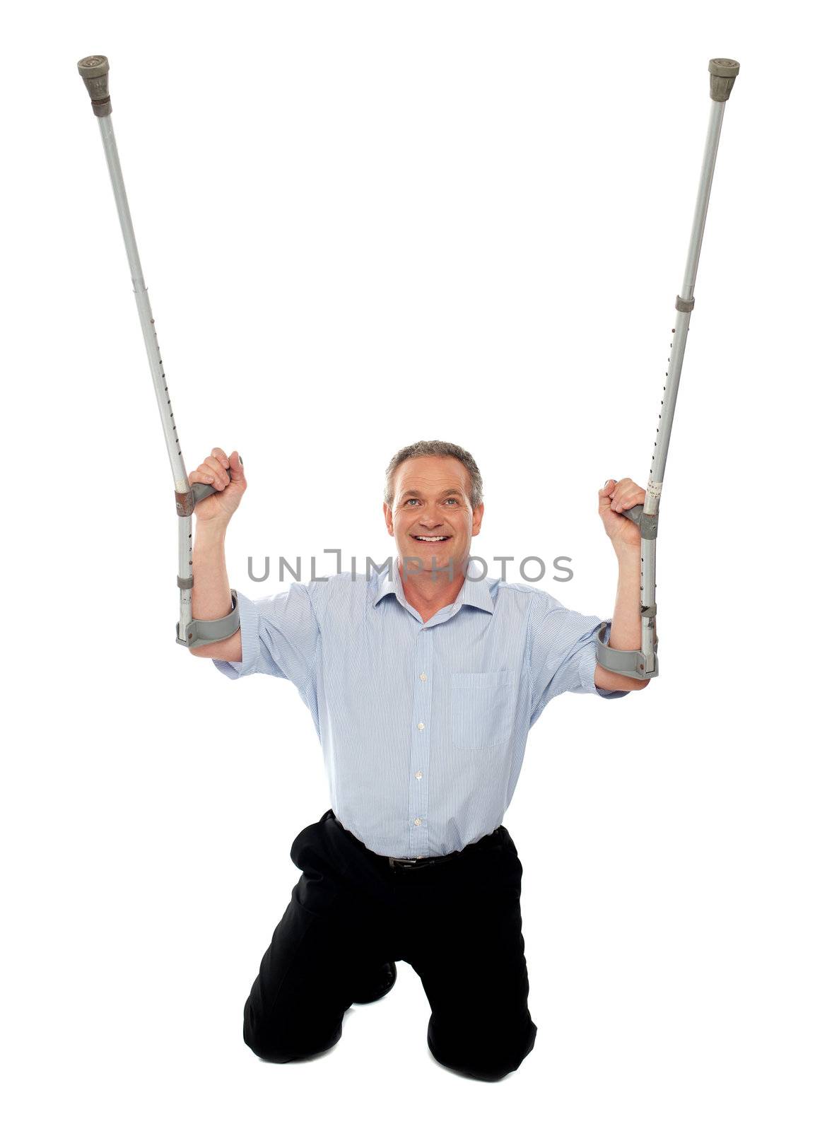 Aged man thanking God while recovering from injury. Sitting on floor and looking upwards