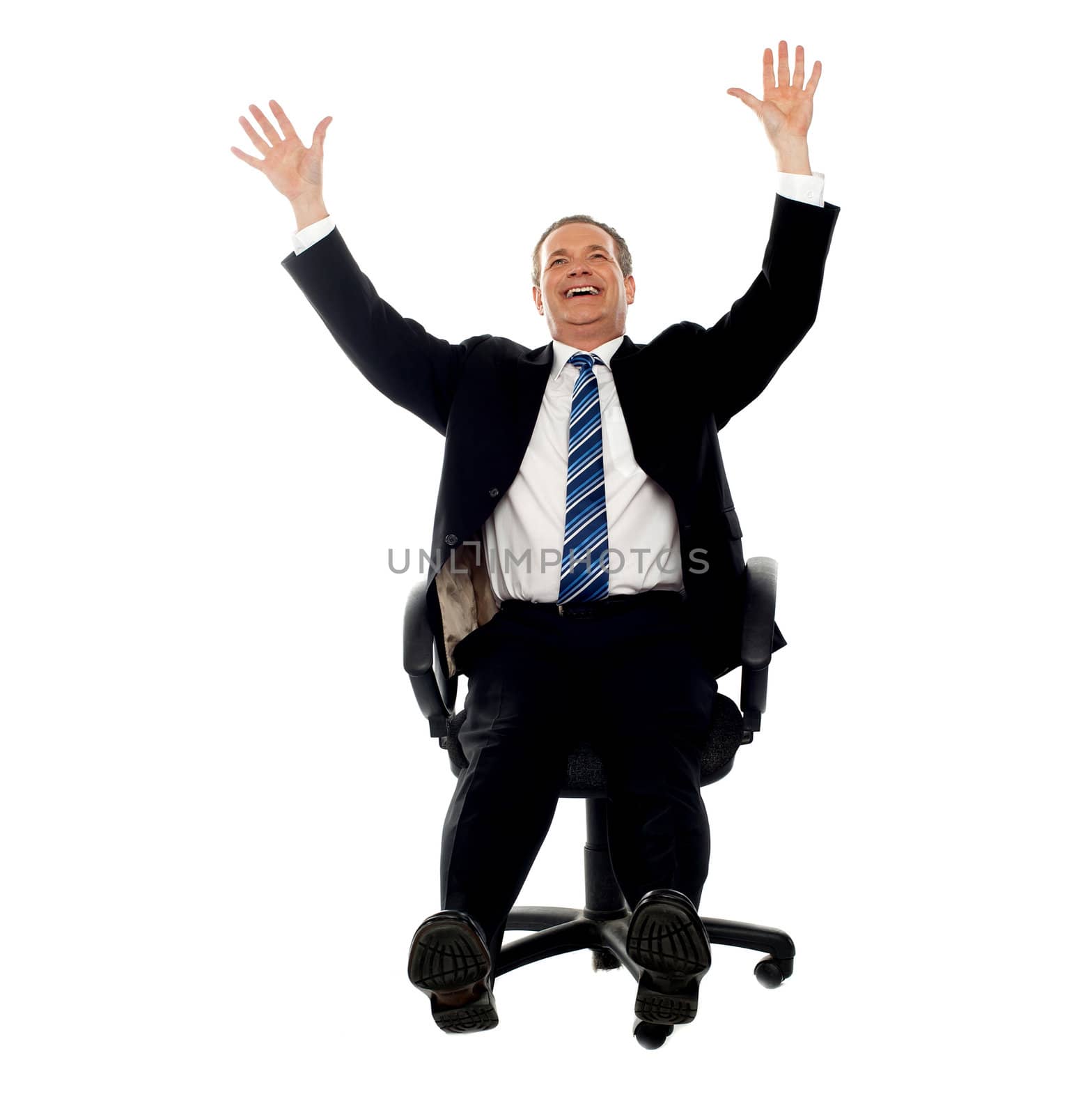 Excited businessman celebrating his success. Arms raised in air.