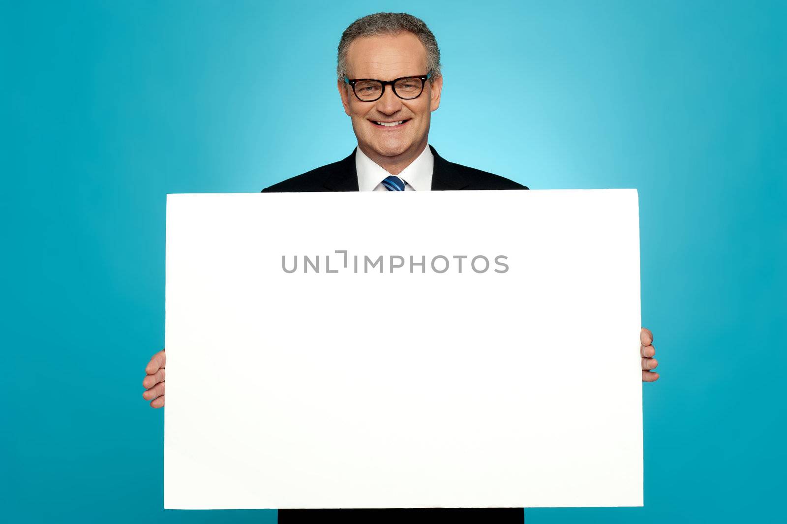 Business representative holding blank ad board and smiling at camera