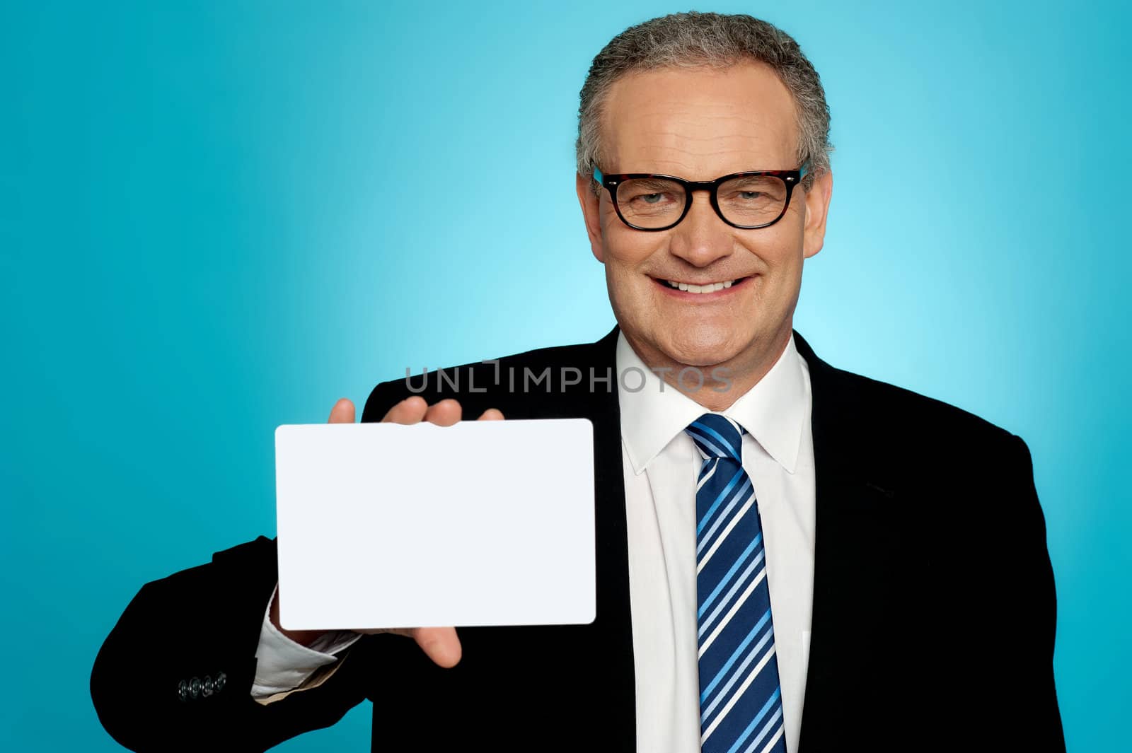 Businessman wearing glasses showing blank white placard to camera