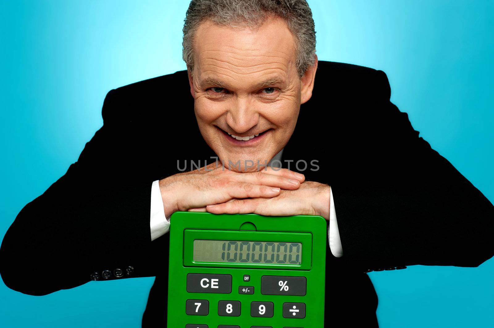 Aged corporate male resting face on big calculator looking at camera