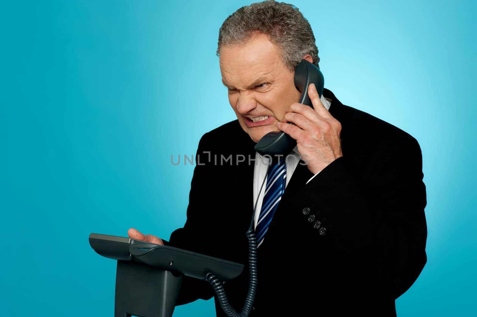 Irritated businessman communicating on phone. Anger expression on his face