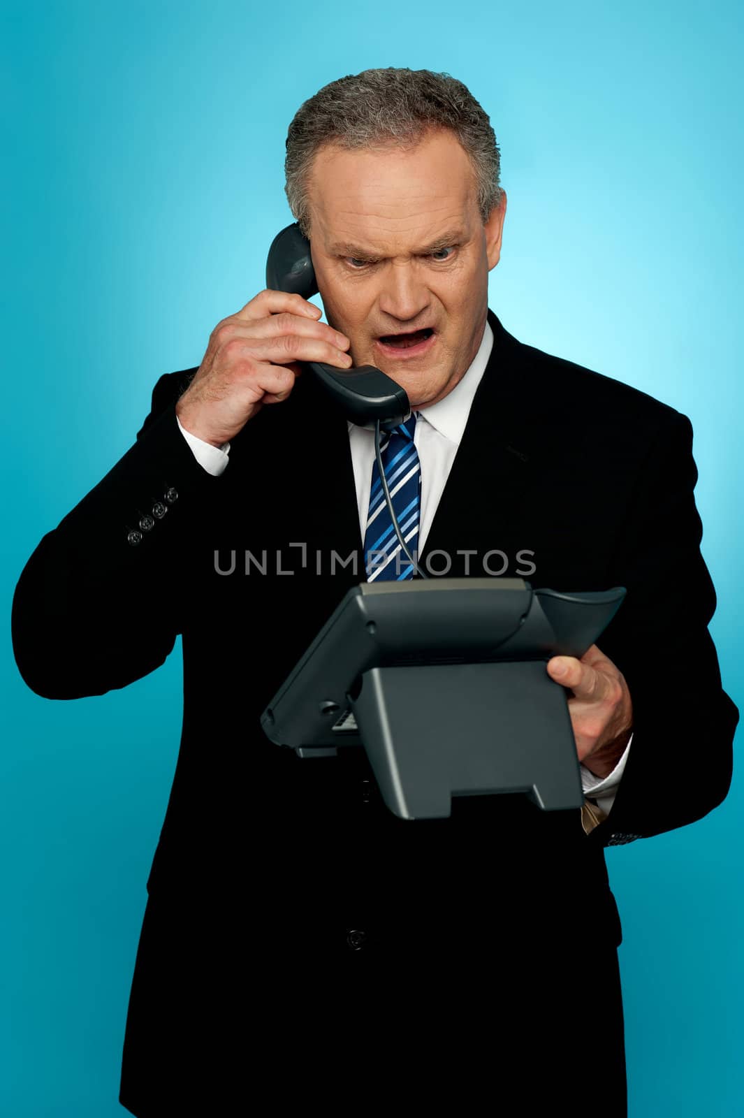 Angry aged corporate man yelling on phone isolated against gradient background