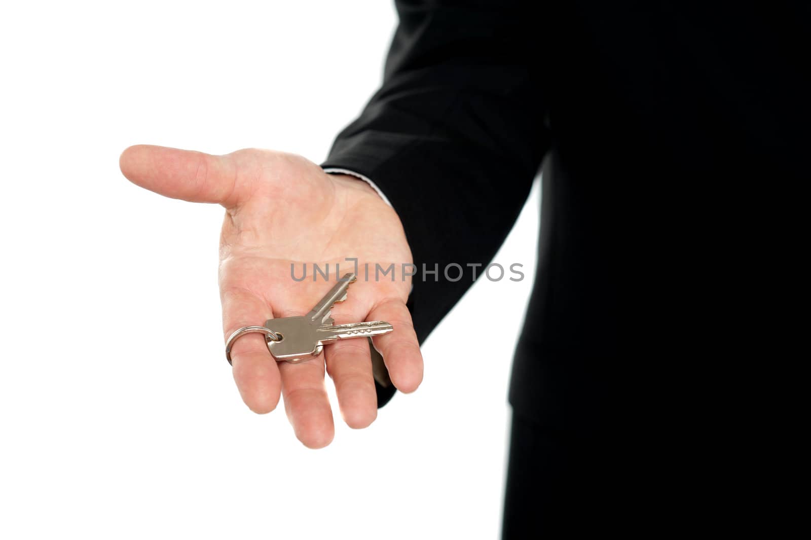Businessman offering keys, closeup shot. Isolated over white background