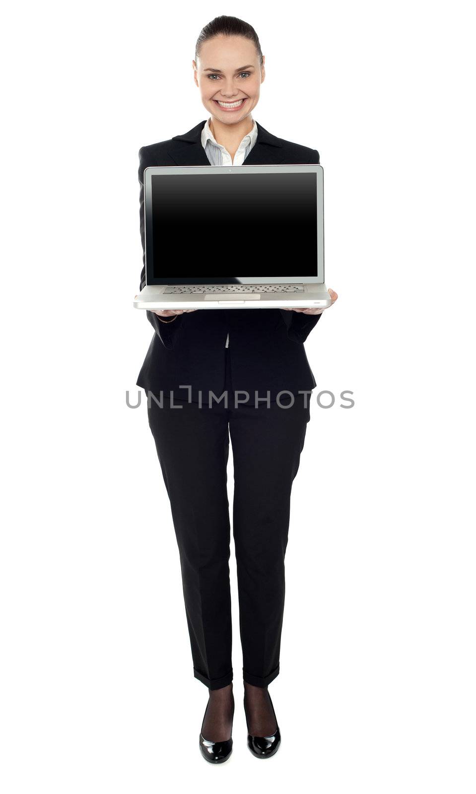 Full length portrait of attractive smiling woman presenting new laptop to you