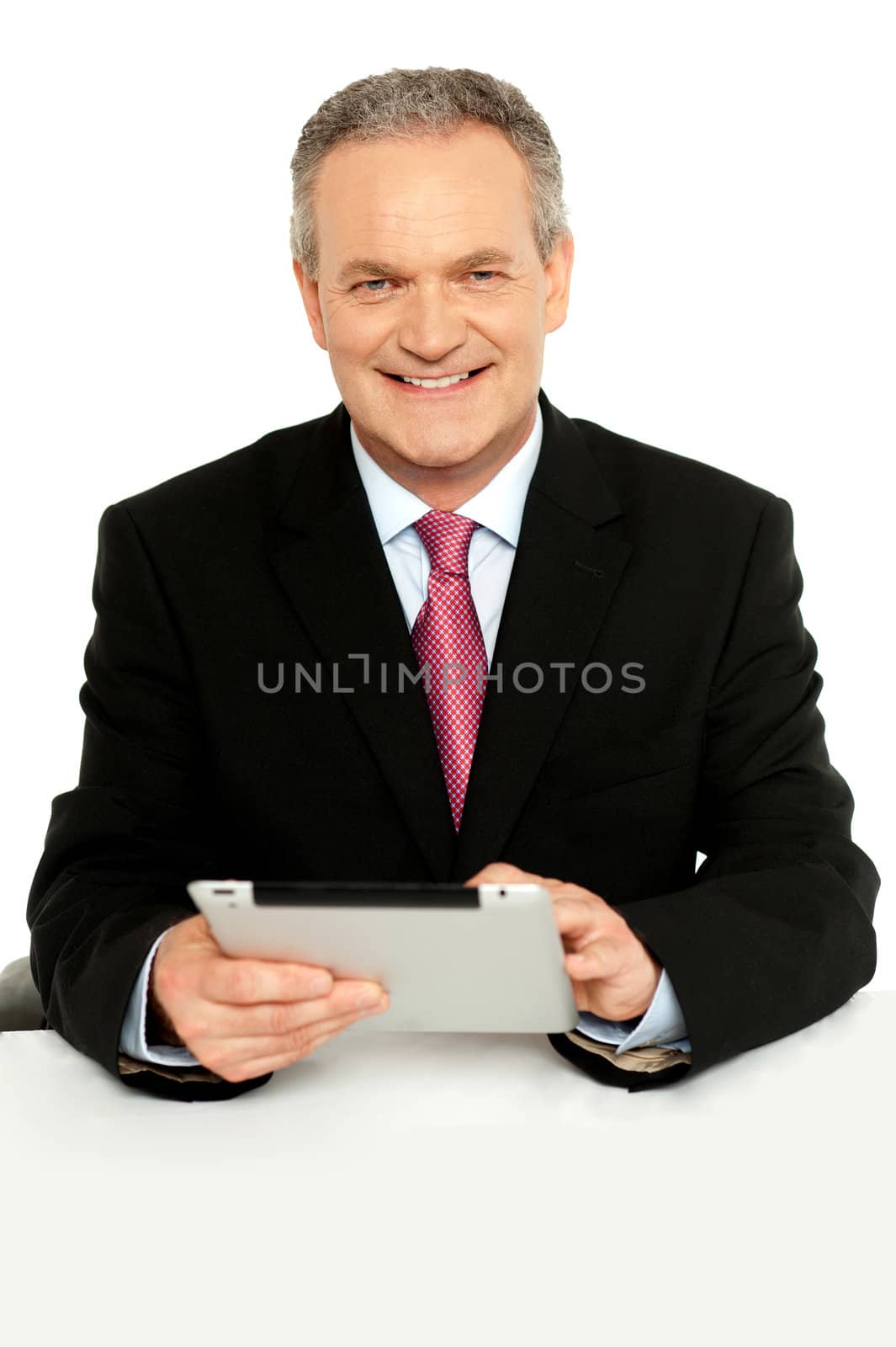Handsome aged business male using tablet pc, smiling at camera