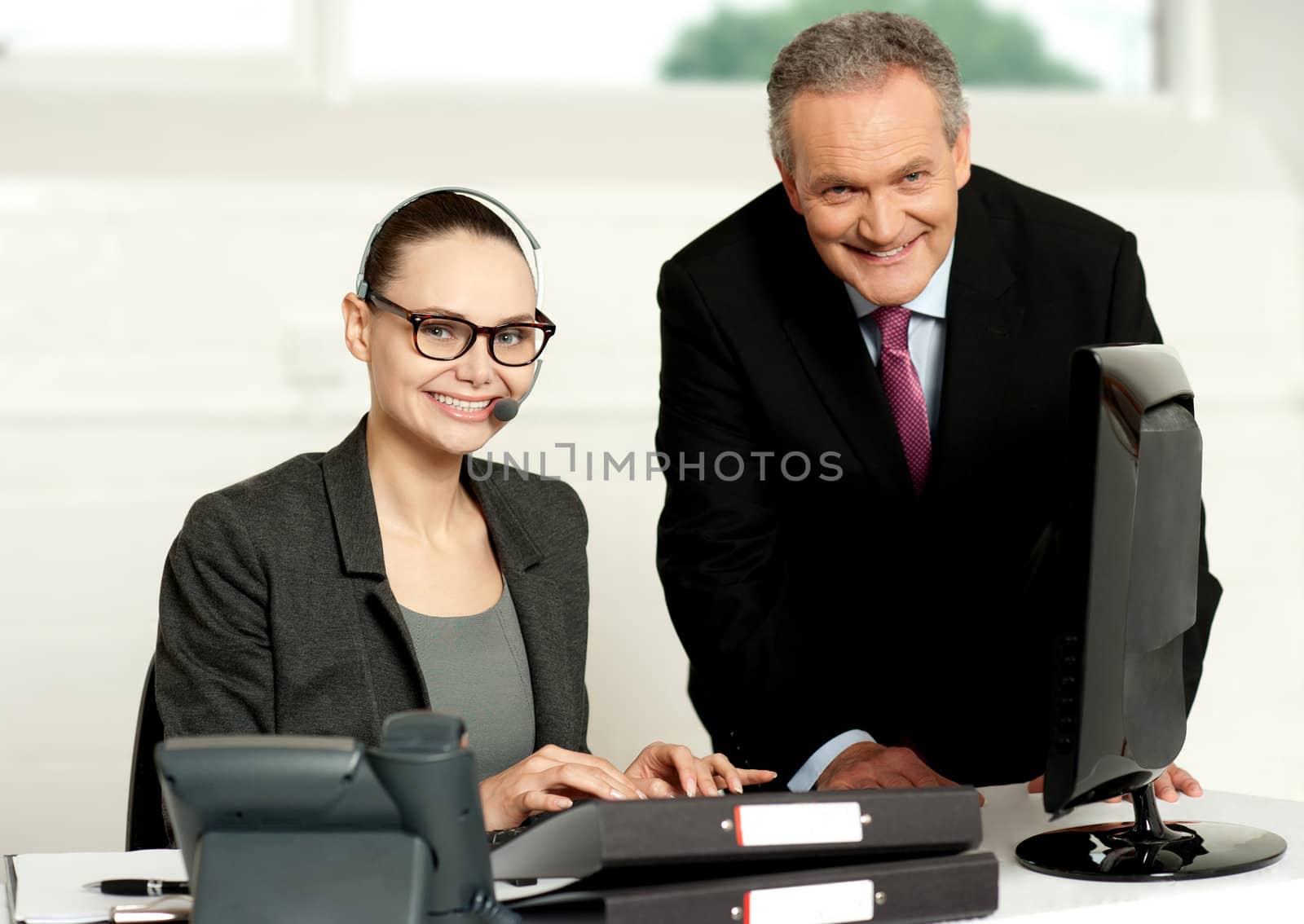 Cheerful corporate people at work in office. Woman typing on keyboard