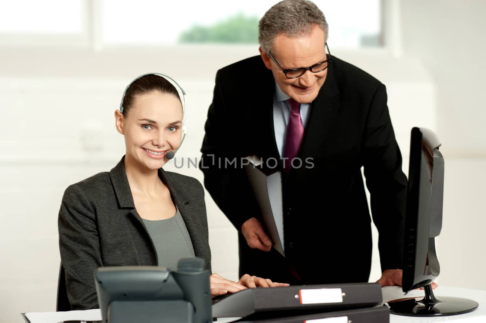 Team of two business executives working in office in front of computer