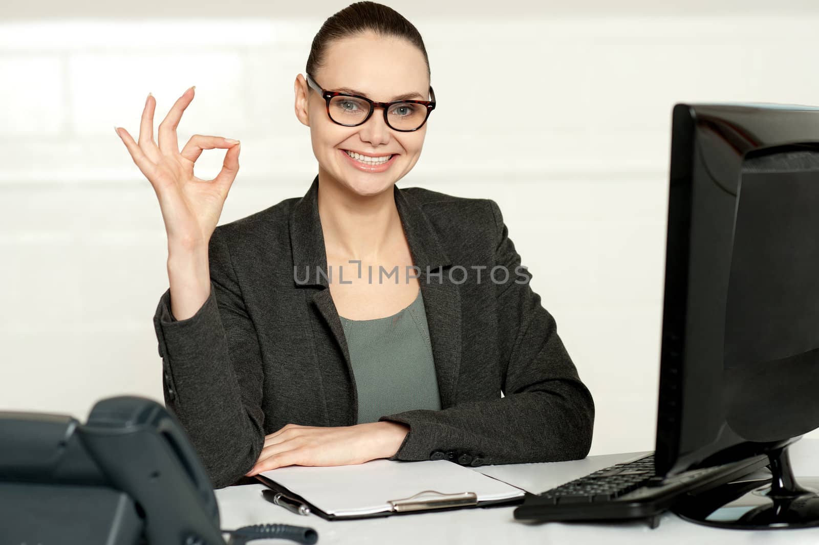 Smiling corporate woman showing excellent gesture to camera