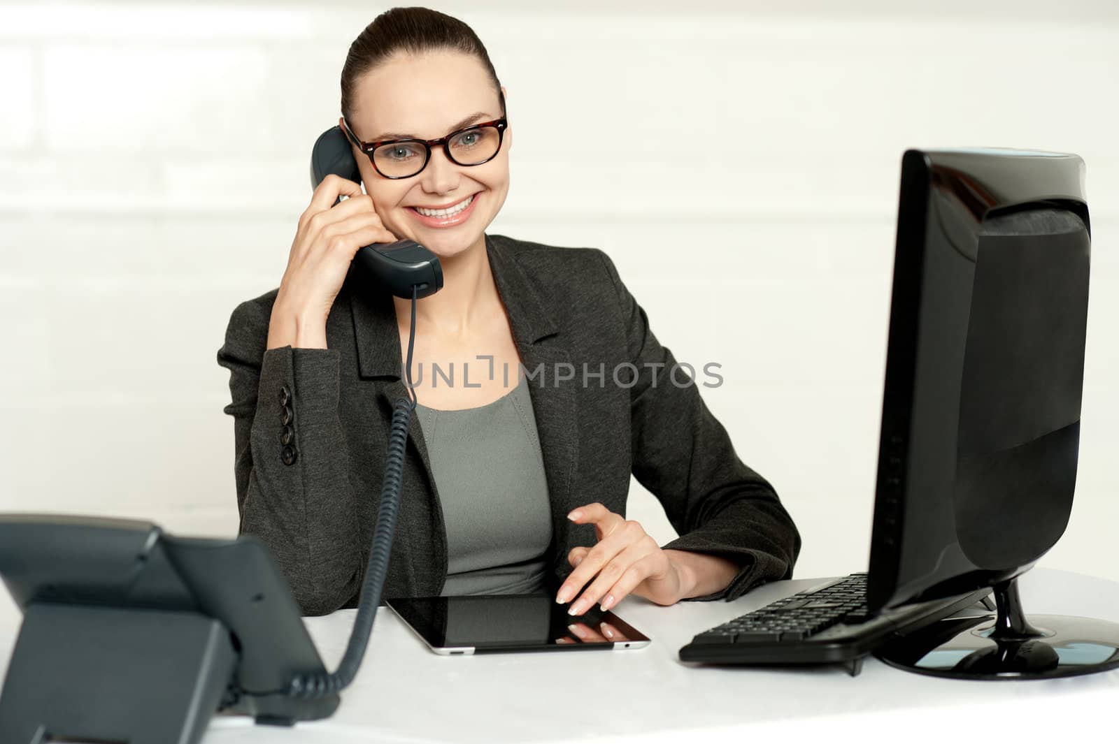 Businesswoman in glasses sitting in her office and communicating on phone