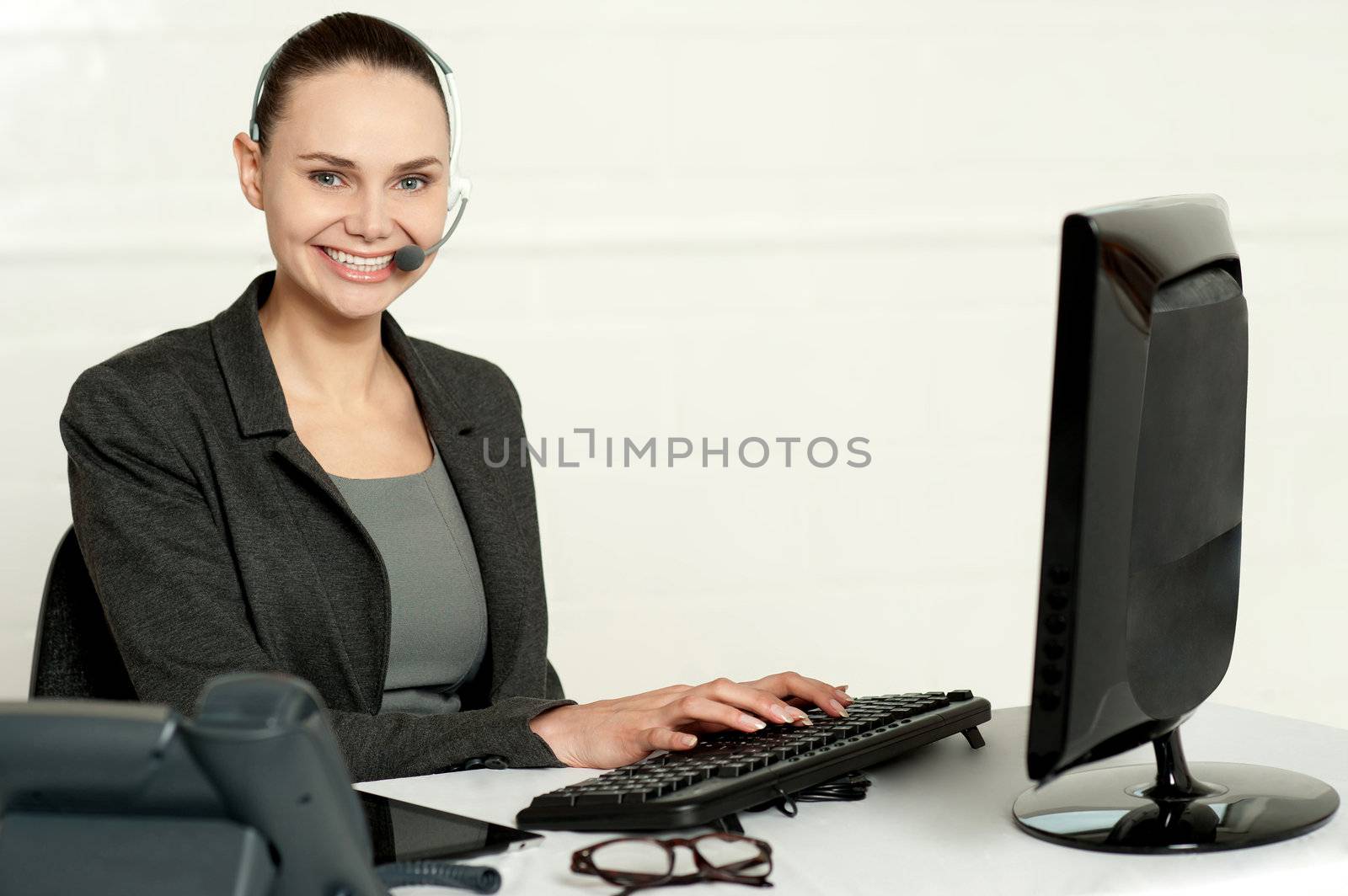Female employee assisting customers typing on keyboard