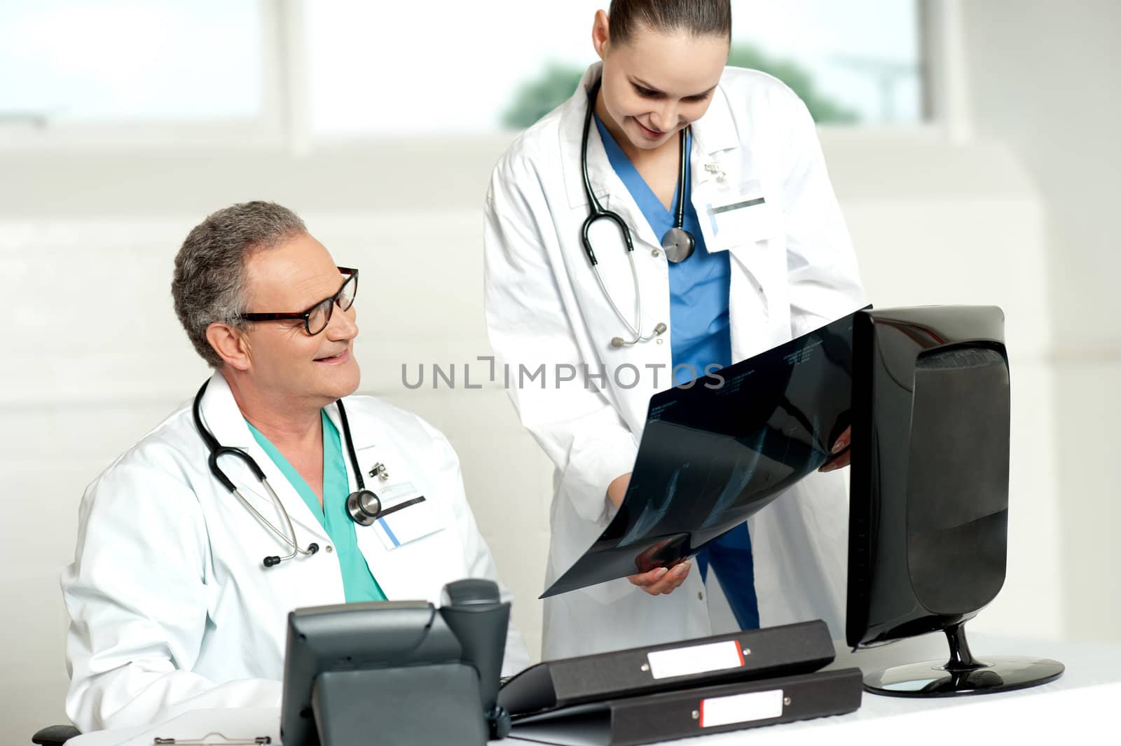 Team of two doctors reviewing x-ray report of a patient in lab