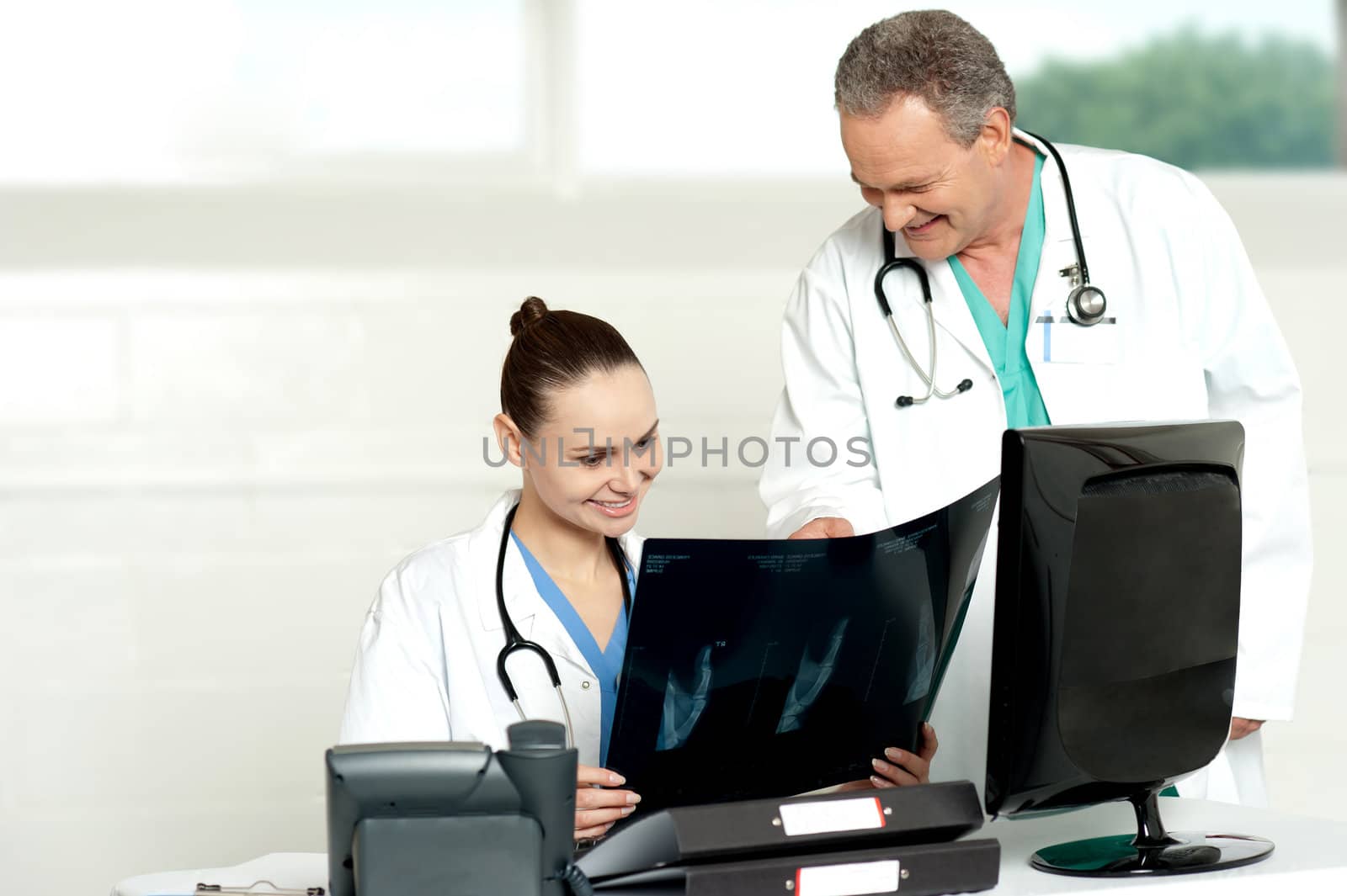 Team of surgeons discussing x-ray report in their chamber. All looks fine in report