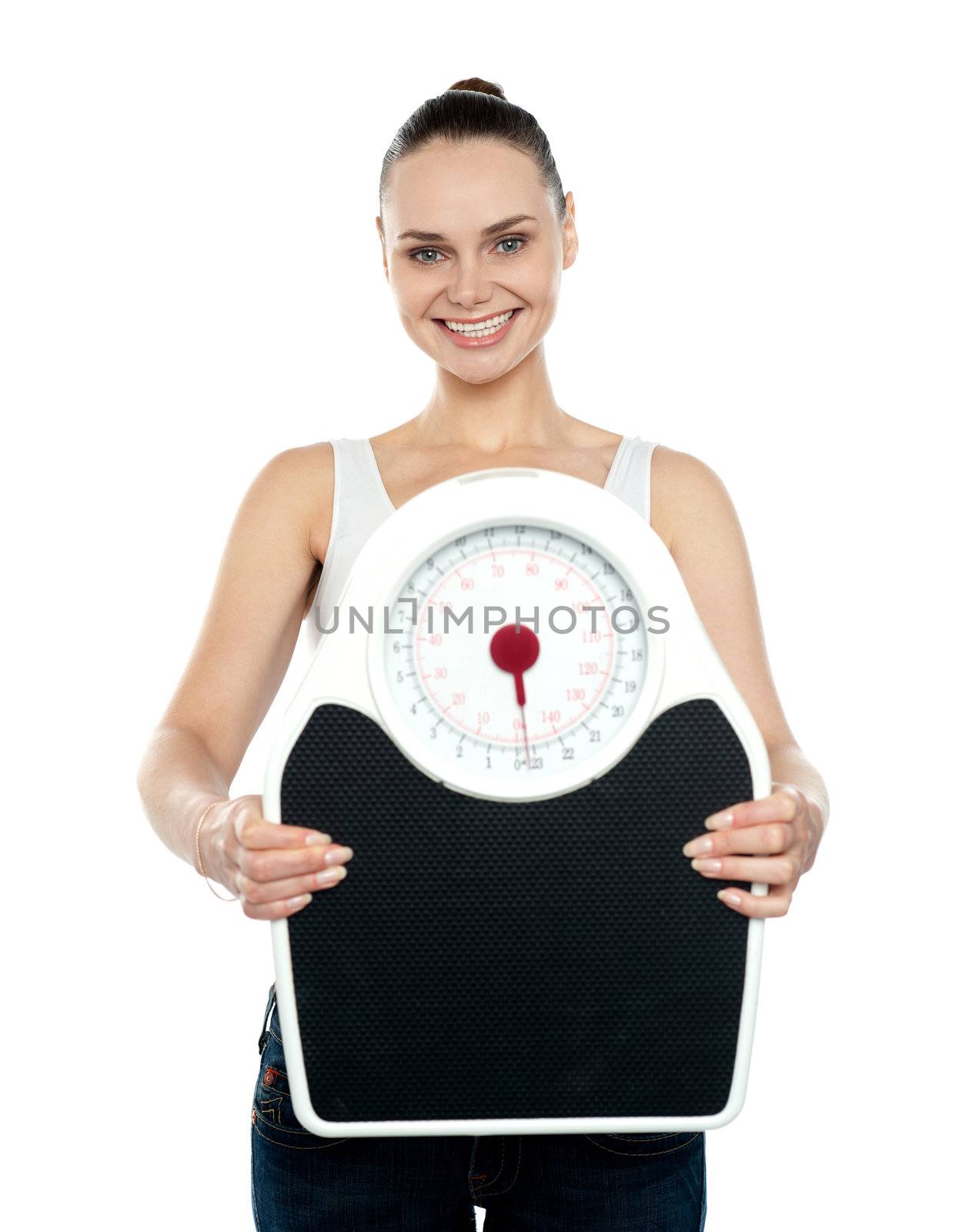 Portrait of cheerful young woman holding a weighing scale against white background