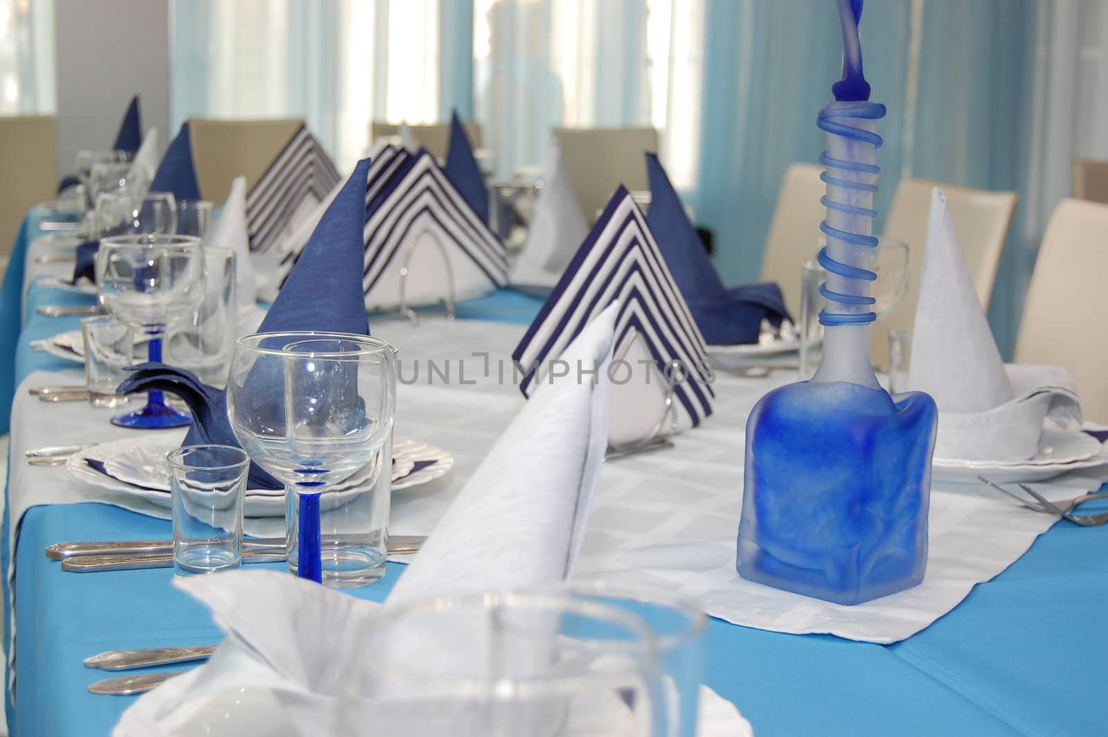 Everything is executed in is white blue color.
Wineglass and napkin in restaurant.