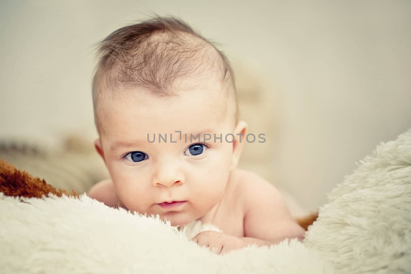 blue eyed baby boy lying and looking into camera