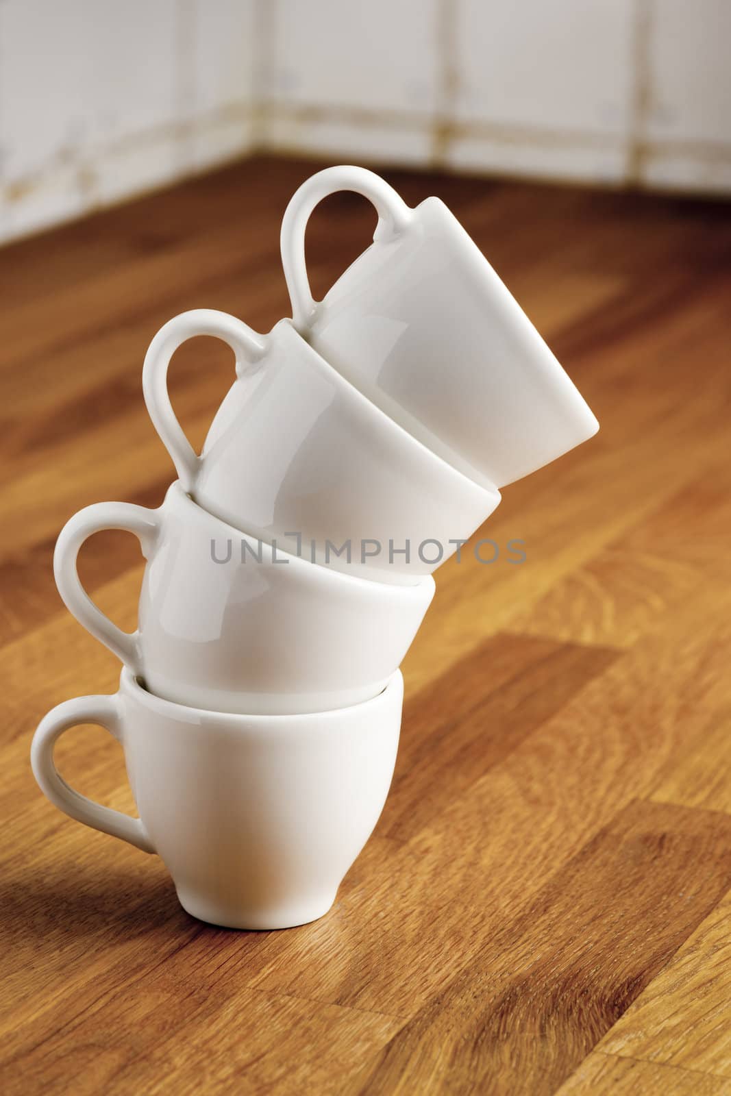 Stack of four white china coffee cups.