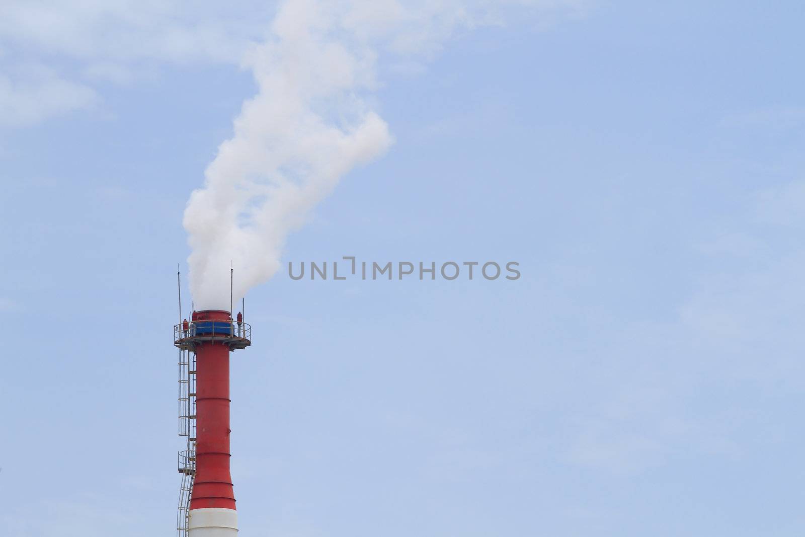 Plant pipe with smoke against blue sky