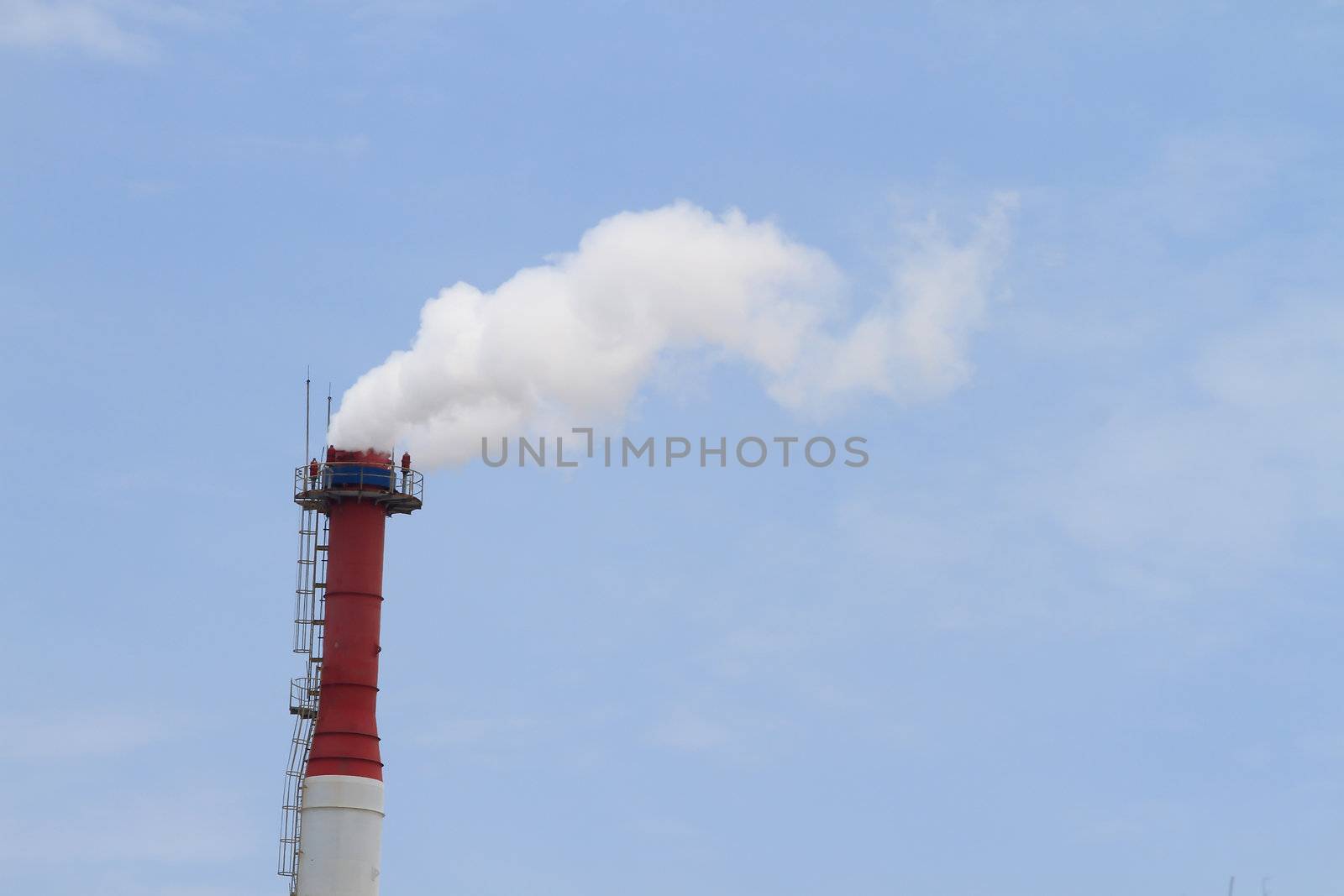 Plant pipe with smoke against blue sky by rufous