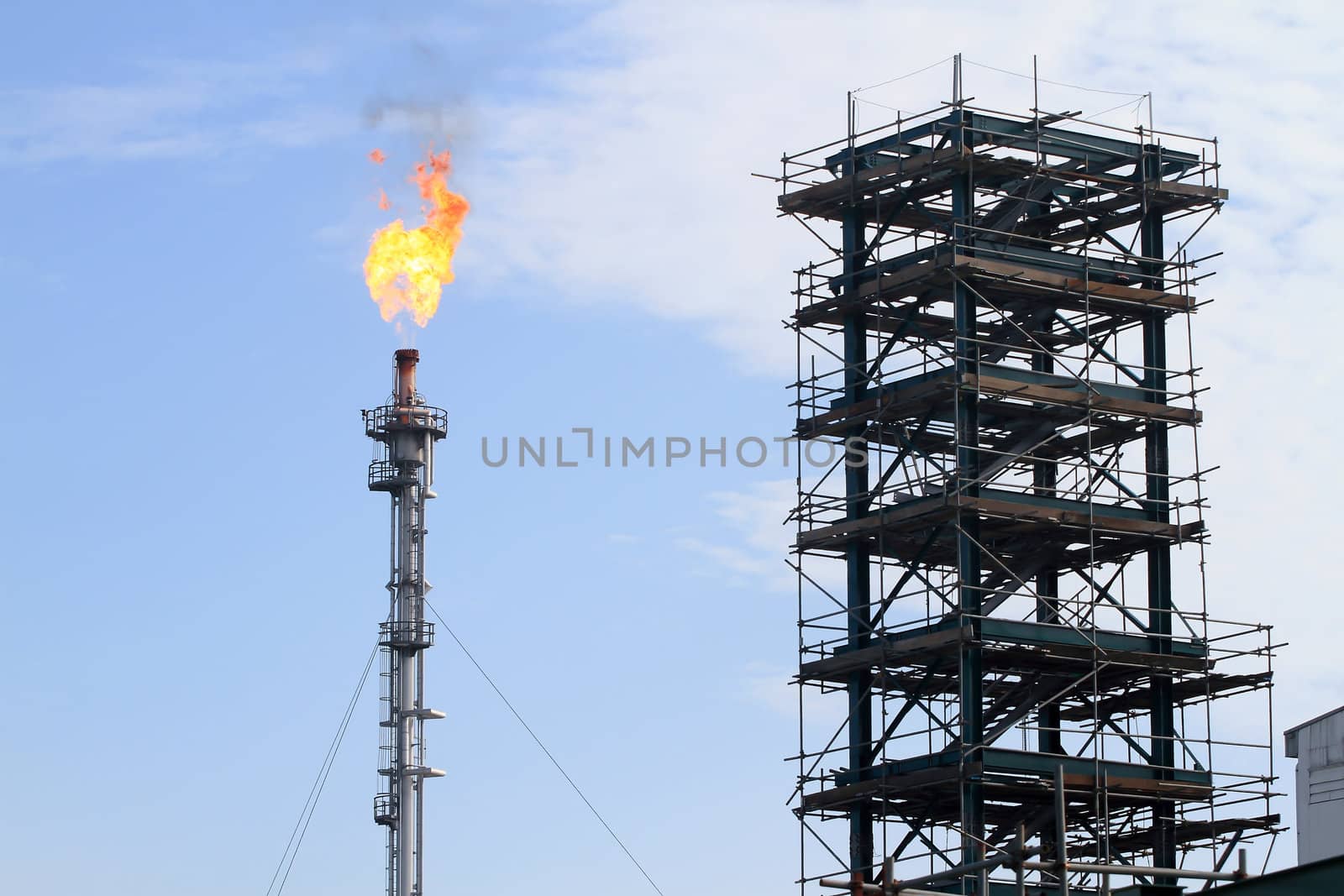 the refinery flare with cloud in background