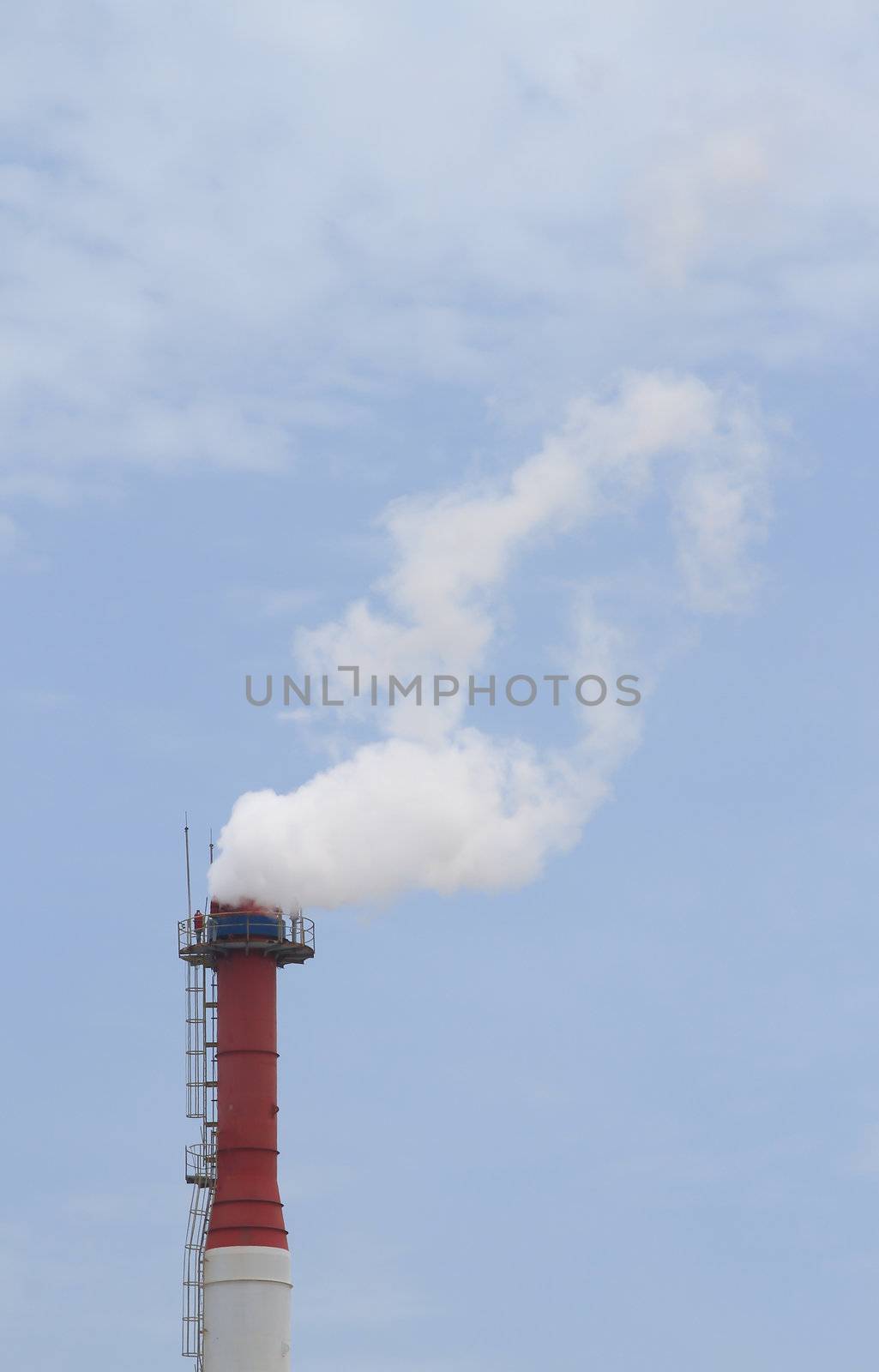 Plant pipe with smoke against blue sky
