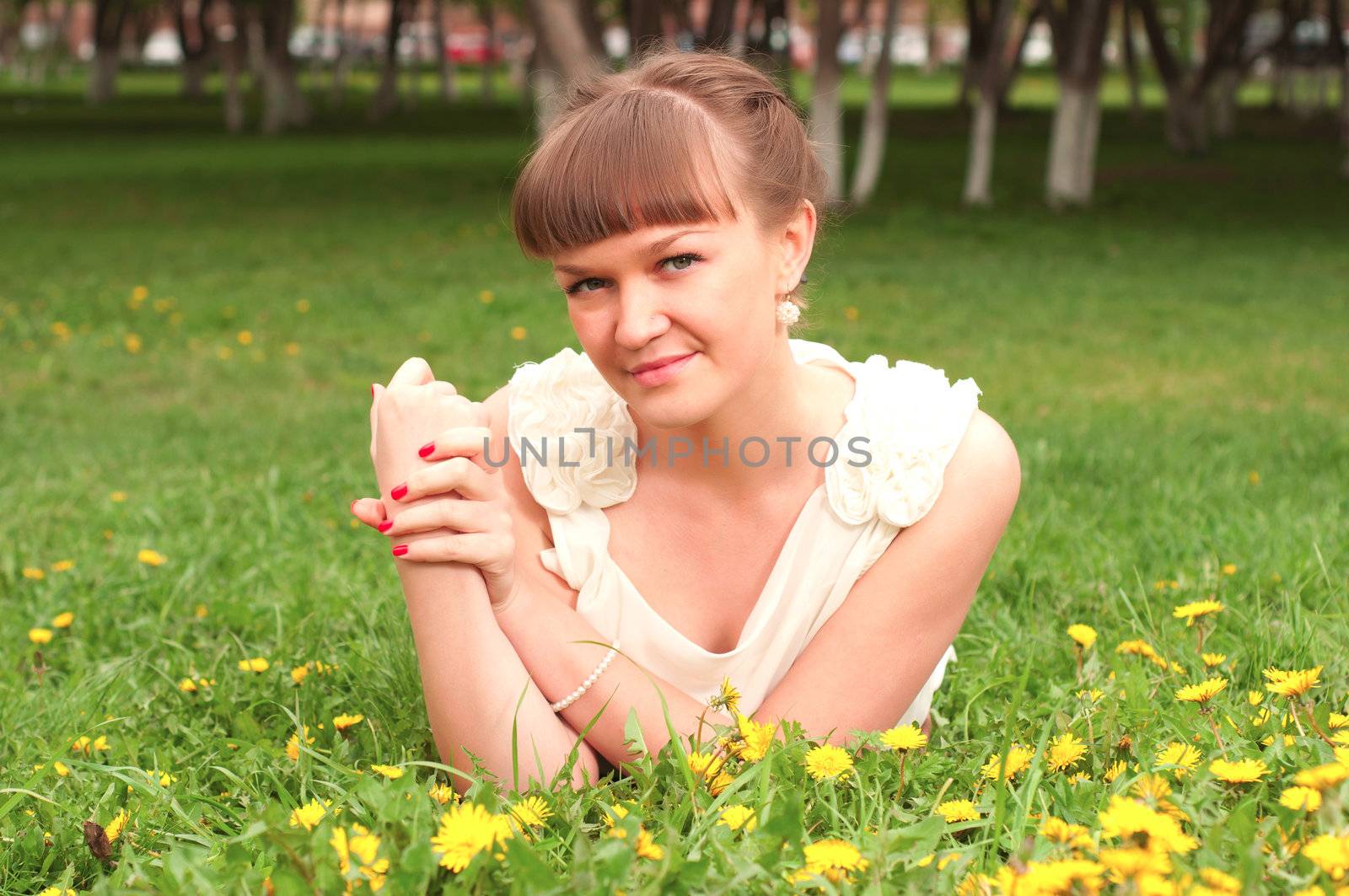 portrait of a beautiful woman lying on the grass in the park