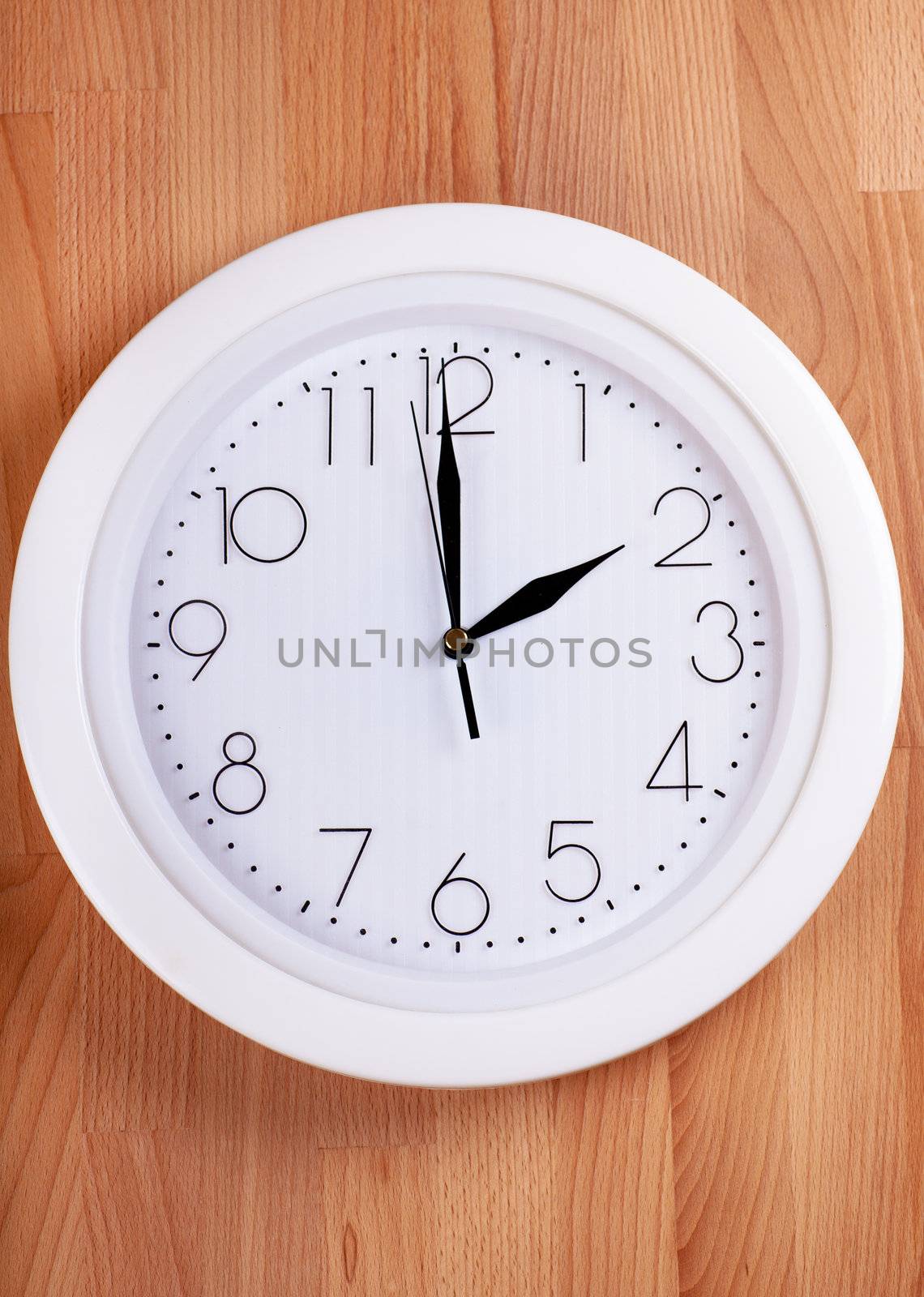 White clock hanging on a wooden wall