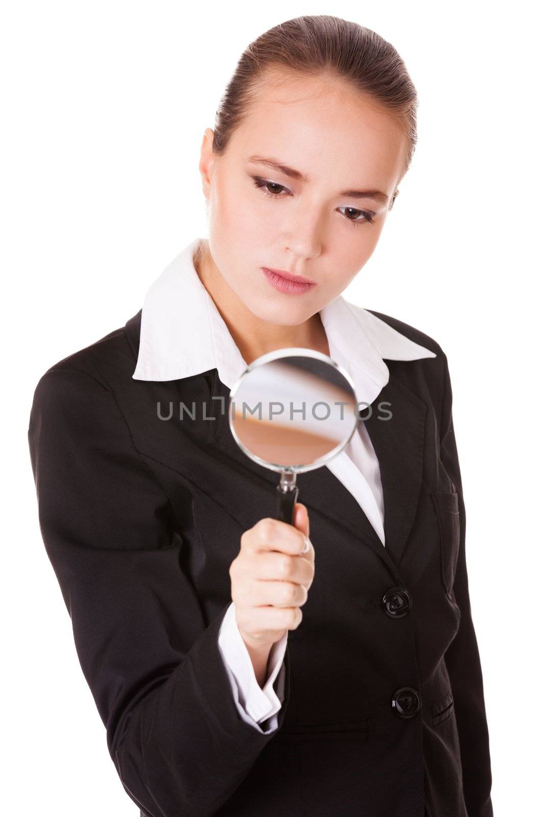 Attentive young business woman looking into a magnifying glass isolated on white background