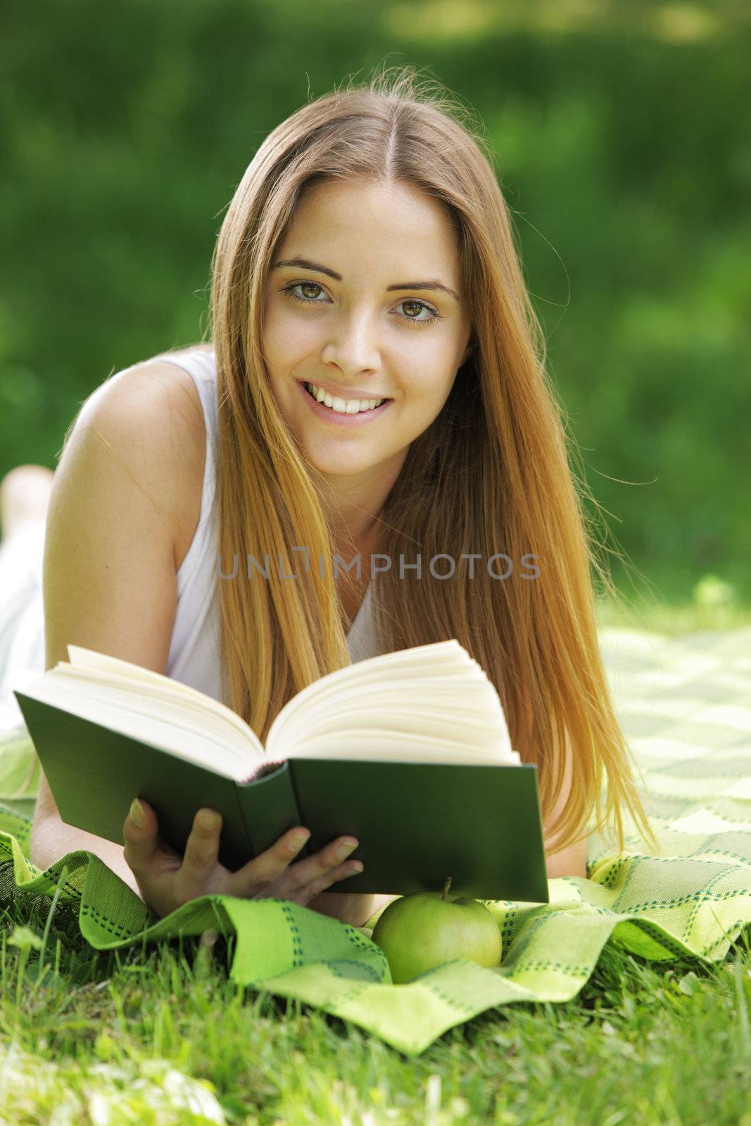 Smiling woman reading book by stokkete