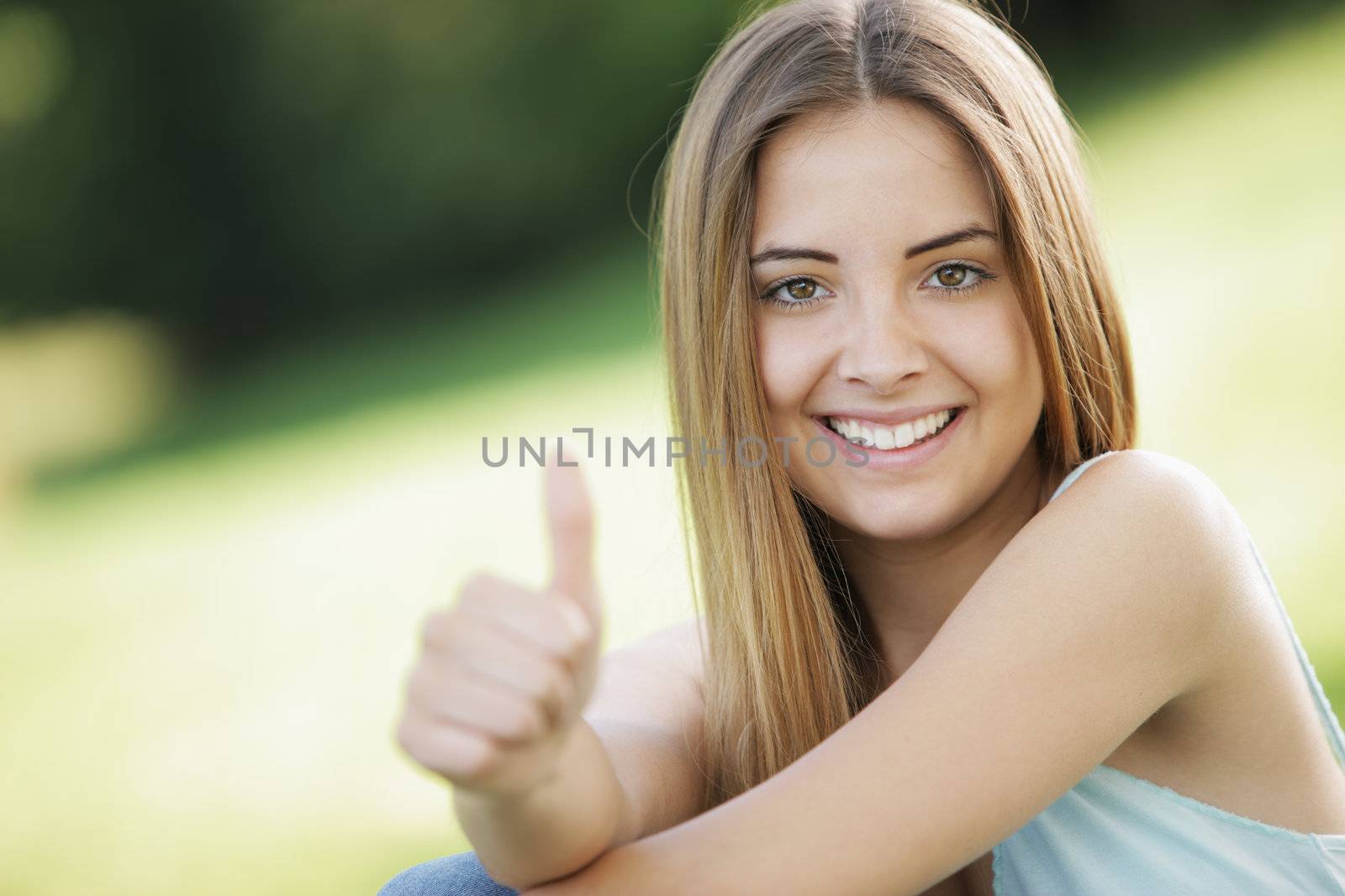 Beautiful young woman showing thumb up sign