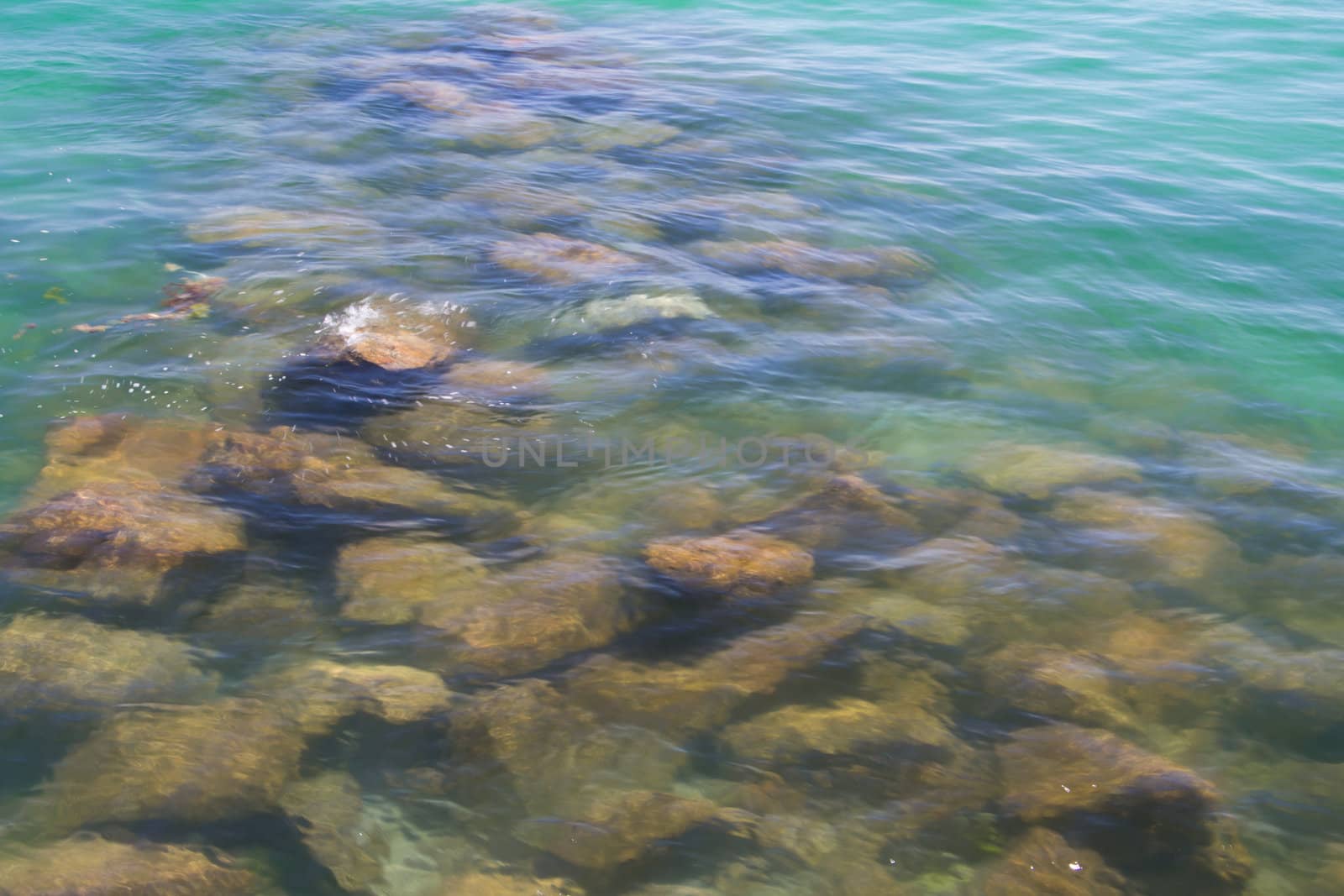 Rocks in the crystal clear waters of a Normandy beach