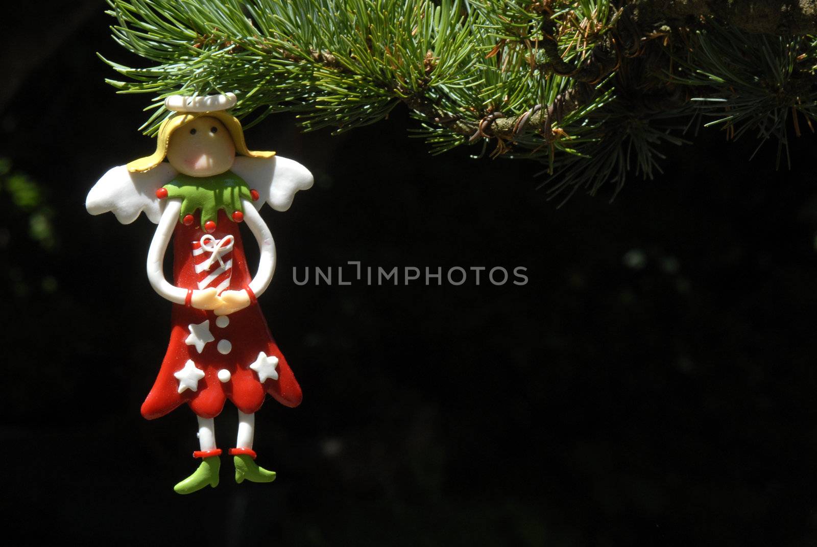 Angel hanging from Christmas tree, copy space