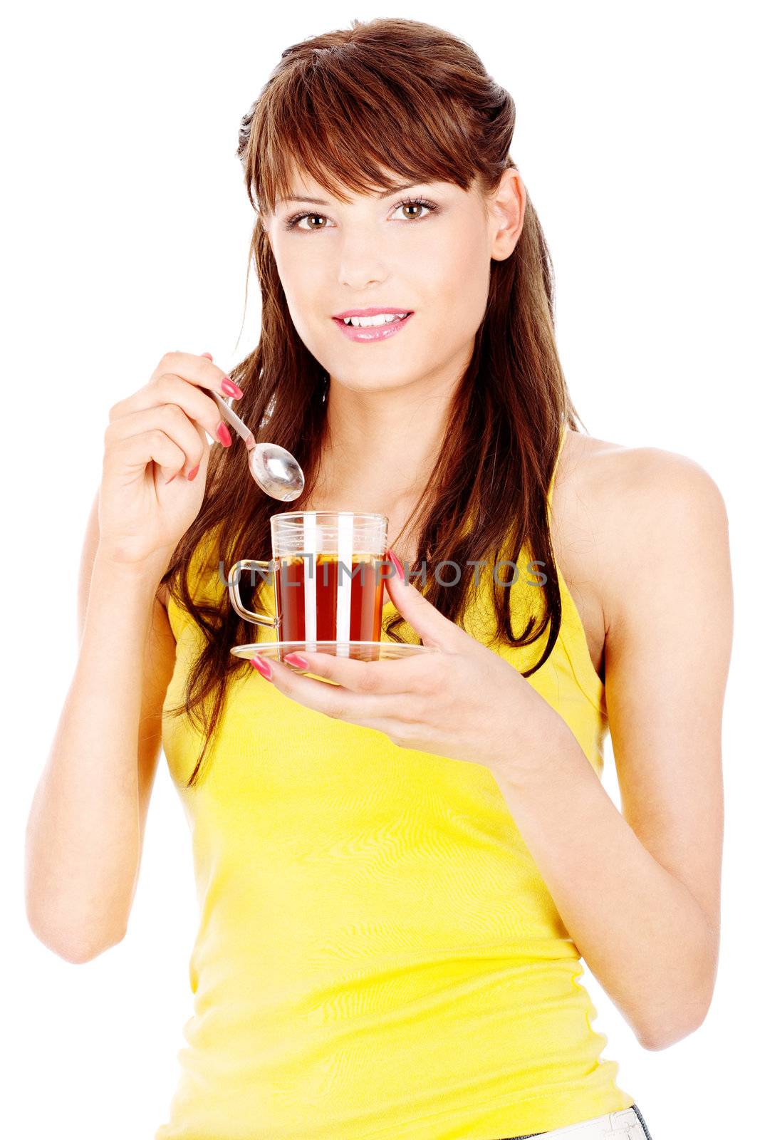 Pretty woman yellow dressed preparing to put spoon in cup of tea, isolated on white background