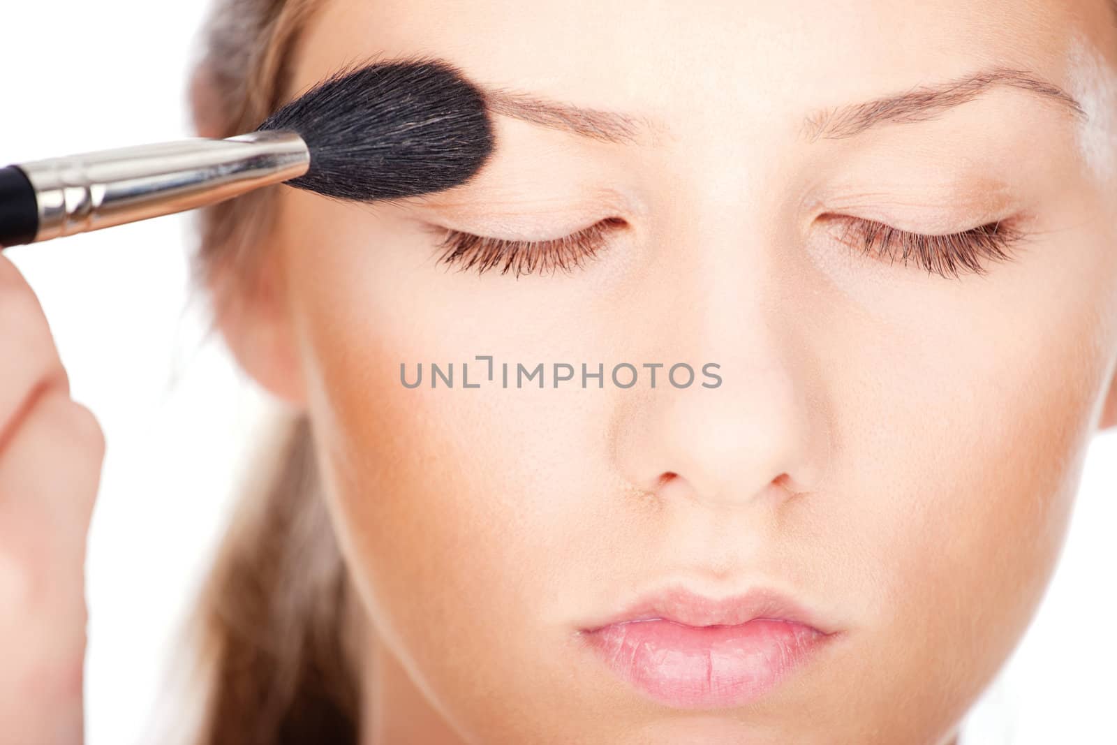 pretty woman applying make up with brush