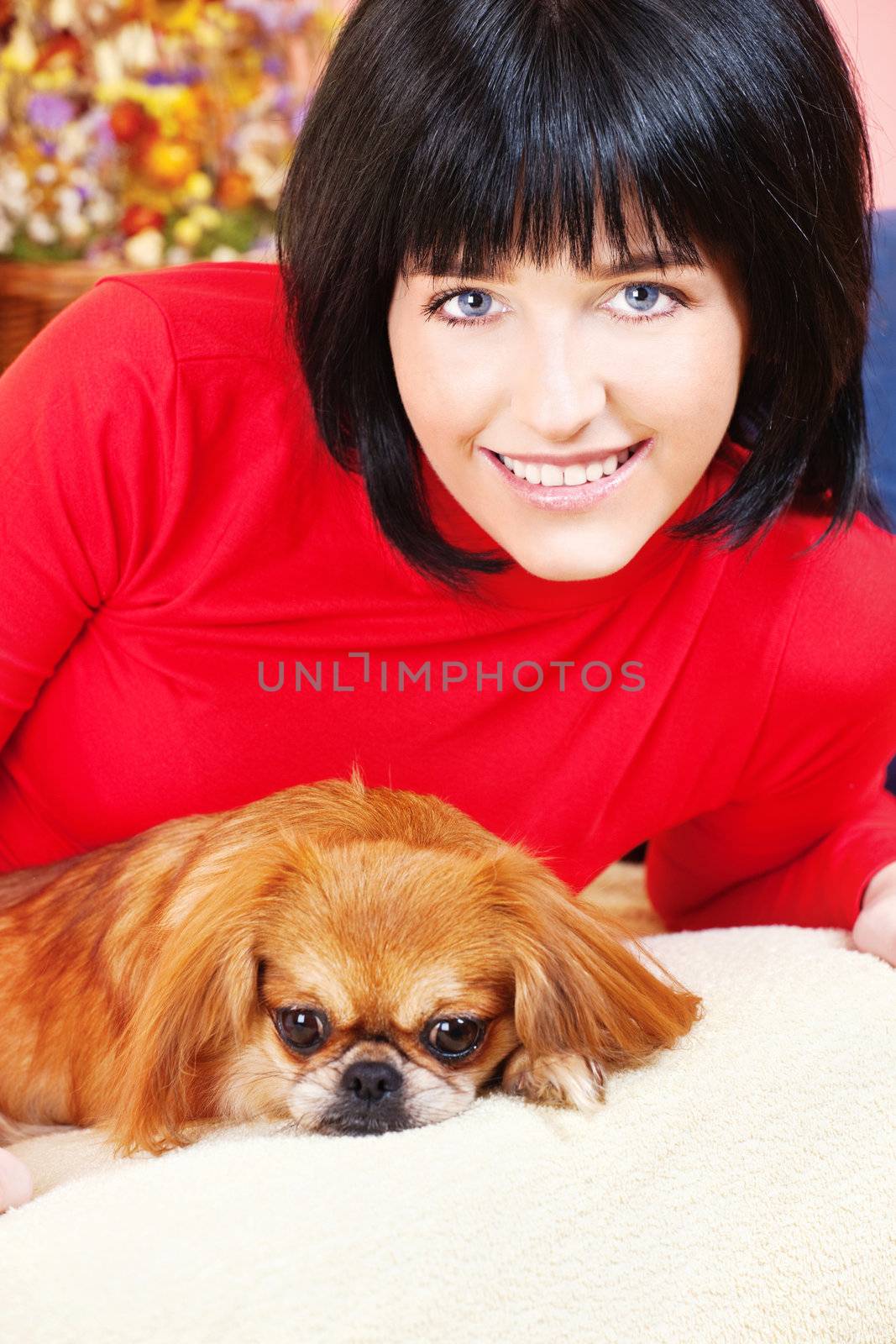 Smiled girl at home with her Pekingese dog