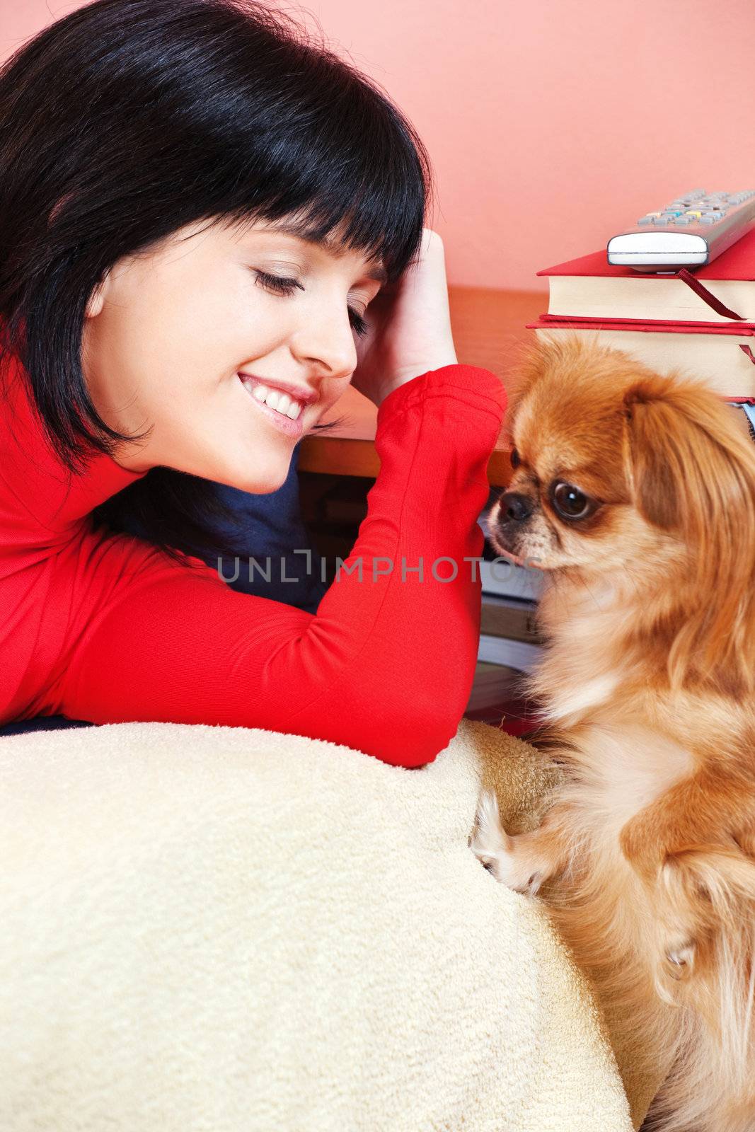 Smiled girl at home with her Pekingese dog