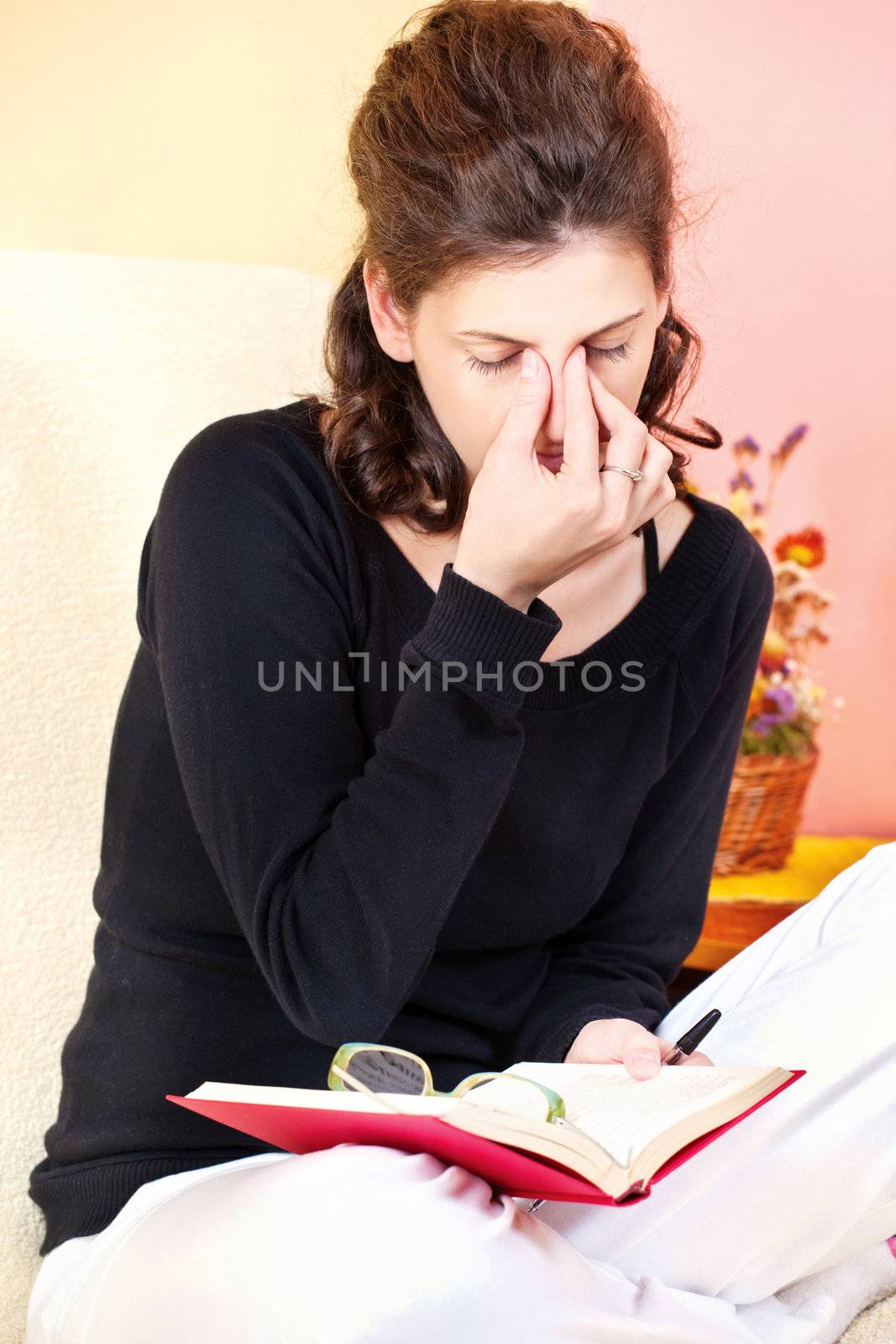 tired young woman of reading book with eyeglasses, at home