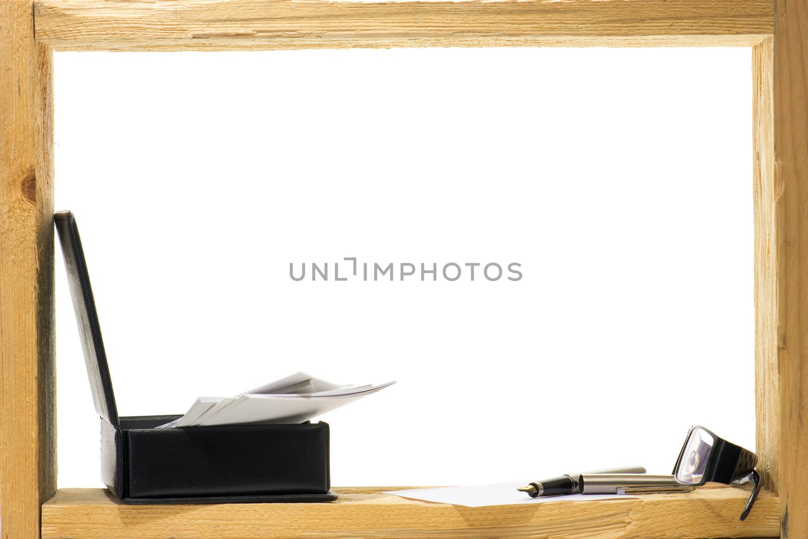 A sheet of white paper and fountain pen with gold nib  inside rough wooden frame on white background