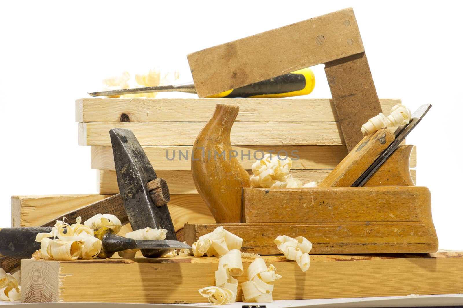 Wooden plane, boards and planed wood shavings on a white background