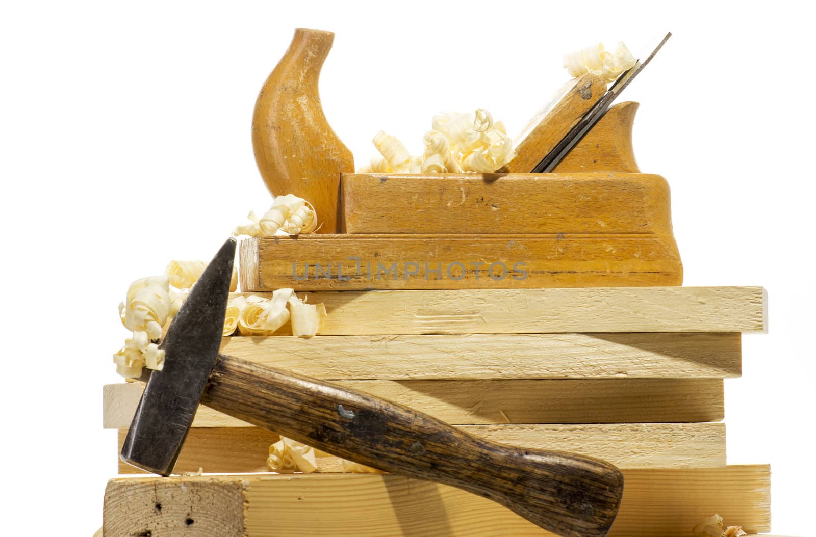 Wooden plane, boards and planed wood shavings on a white background